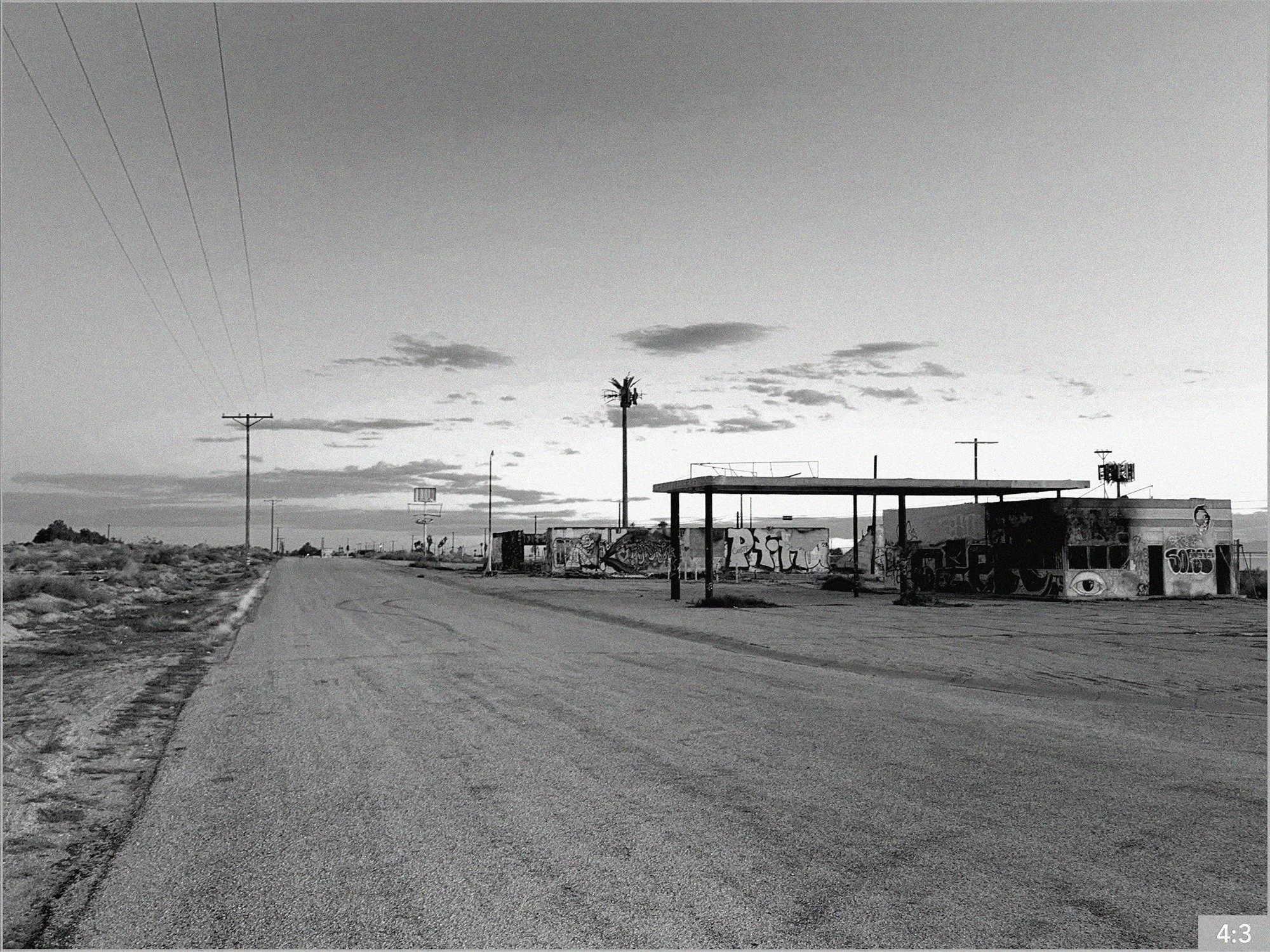 5. Salton Sea North Beach 4:30 pm route 111 98900 block near fire station  *Option-5. SHOT LONG MEDIUM CLOSE: father sits on steps of broken down trailer smoking when a bubble floats beside him.