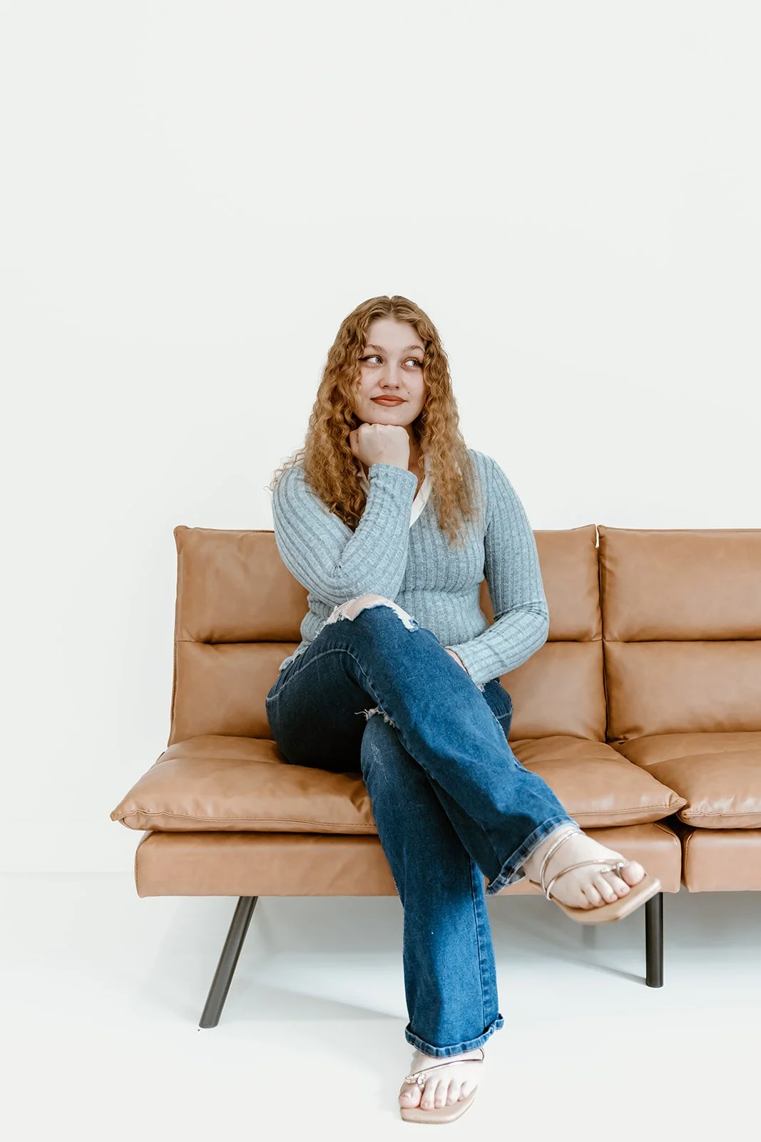 real estate agent sitting on couch for professional headshots for brand presence in peoria illinois