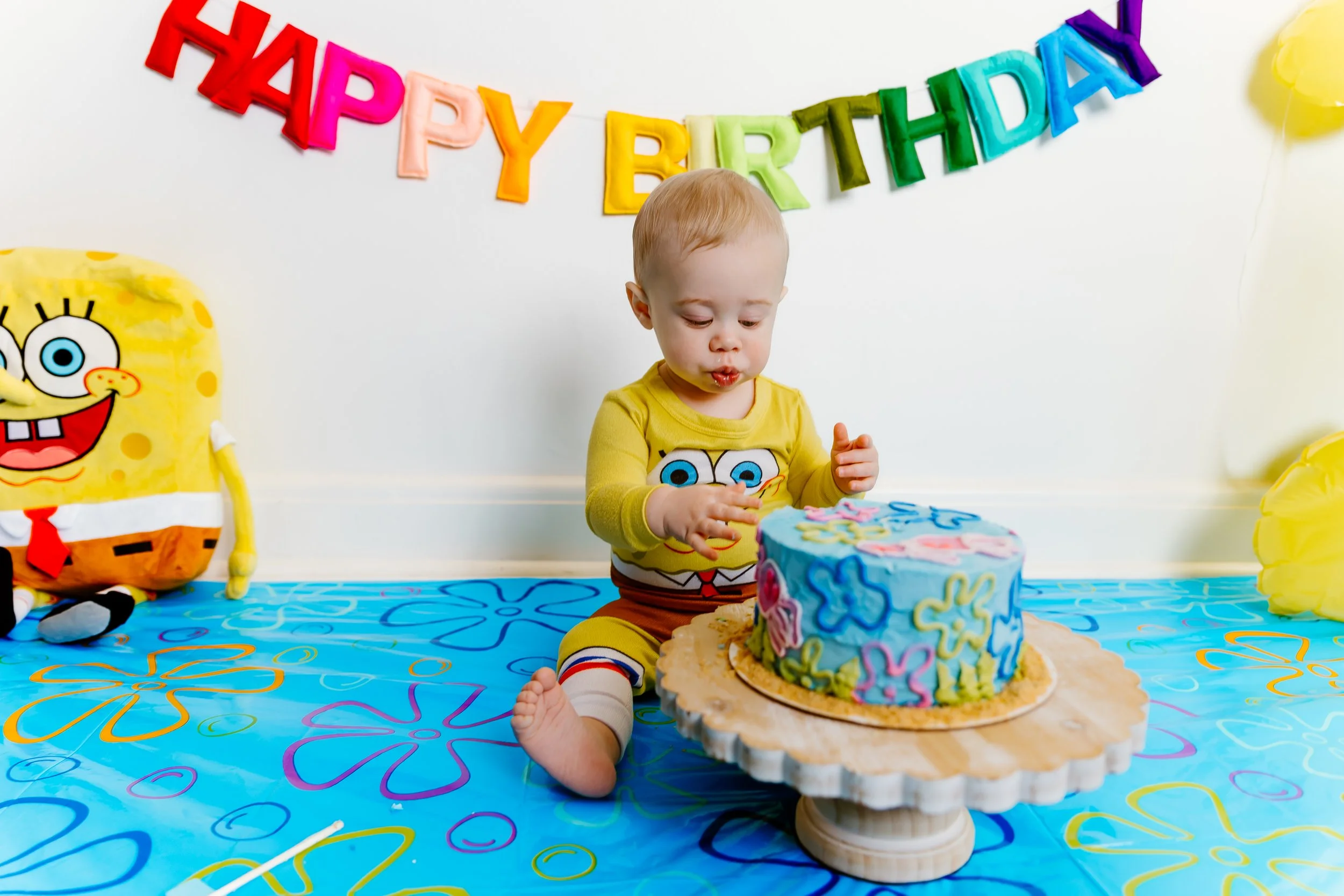 SpongeBob themed first birthday cake smash setup with custom cake