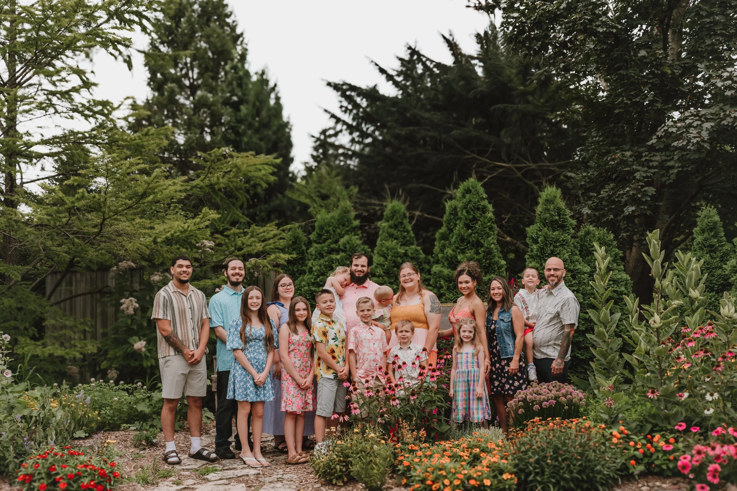 Extended family standing together for an outdoor summer portrait during a family photography session in Central Illinois with grandparents, adult children, and grandchildren.