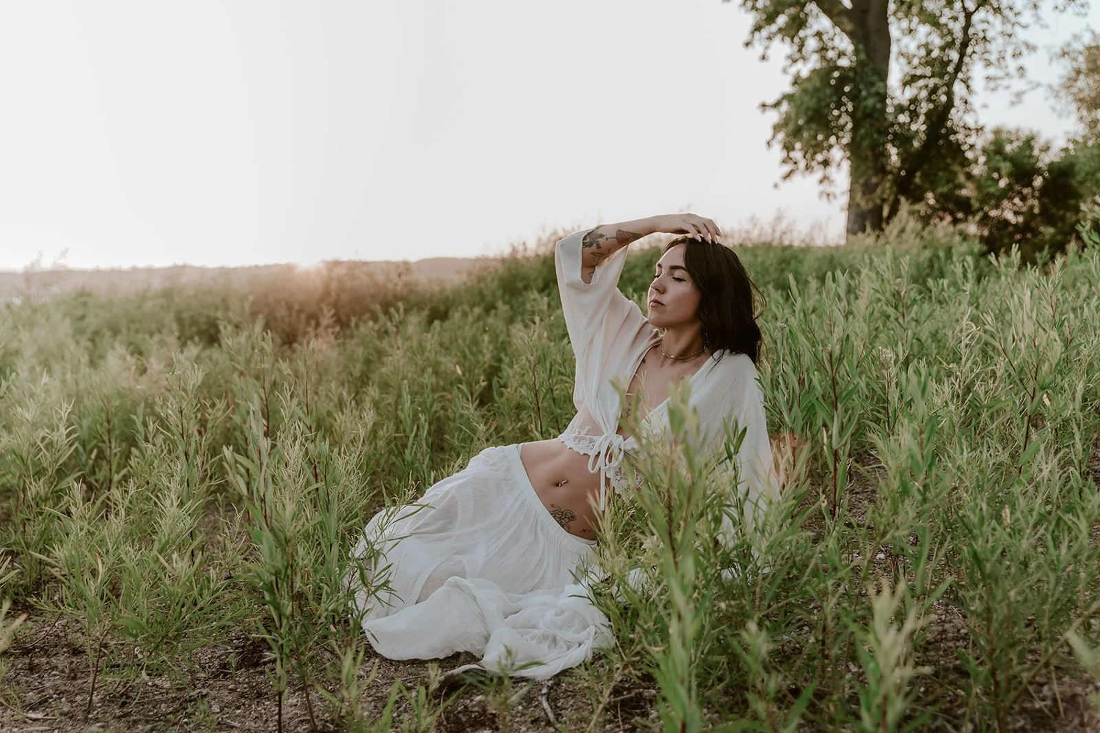 soft boudoir session at Cooper park in east peoria illinois with girl sitting in grass