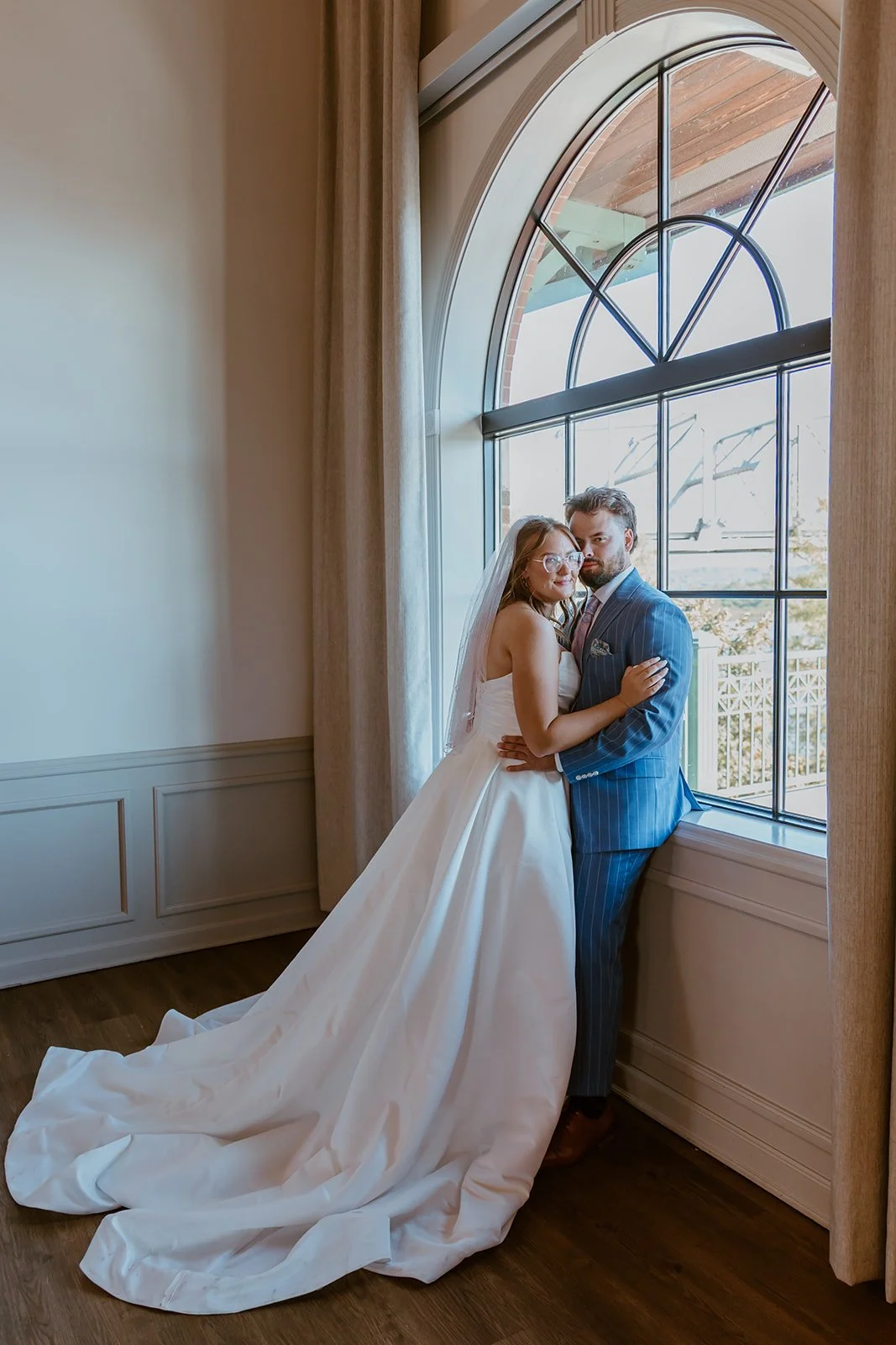 wedding at the gateway building in peoria illinois bride and groom posing by windows