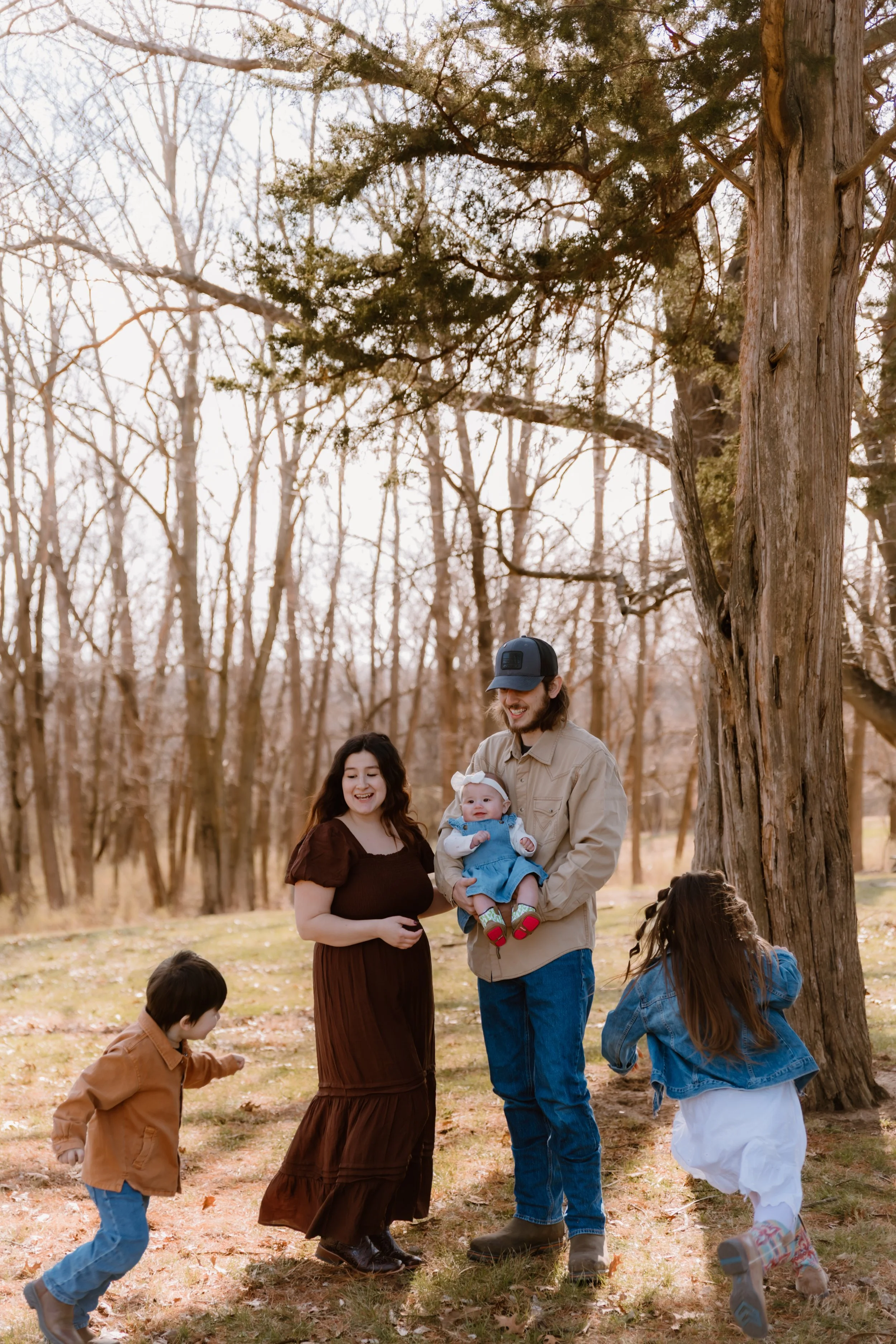 family of five posing together in wooded area central illinois