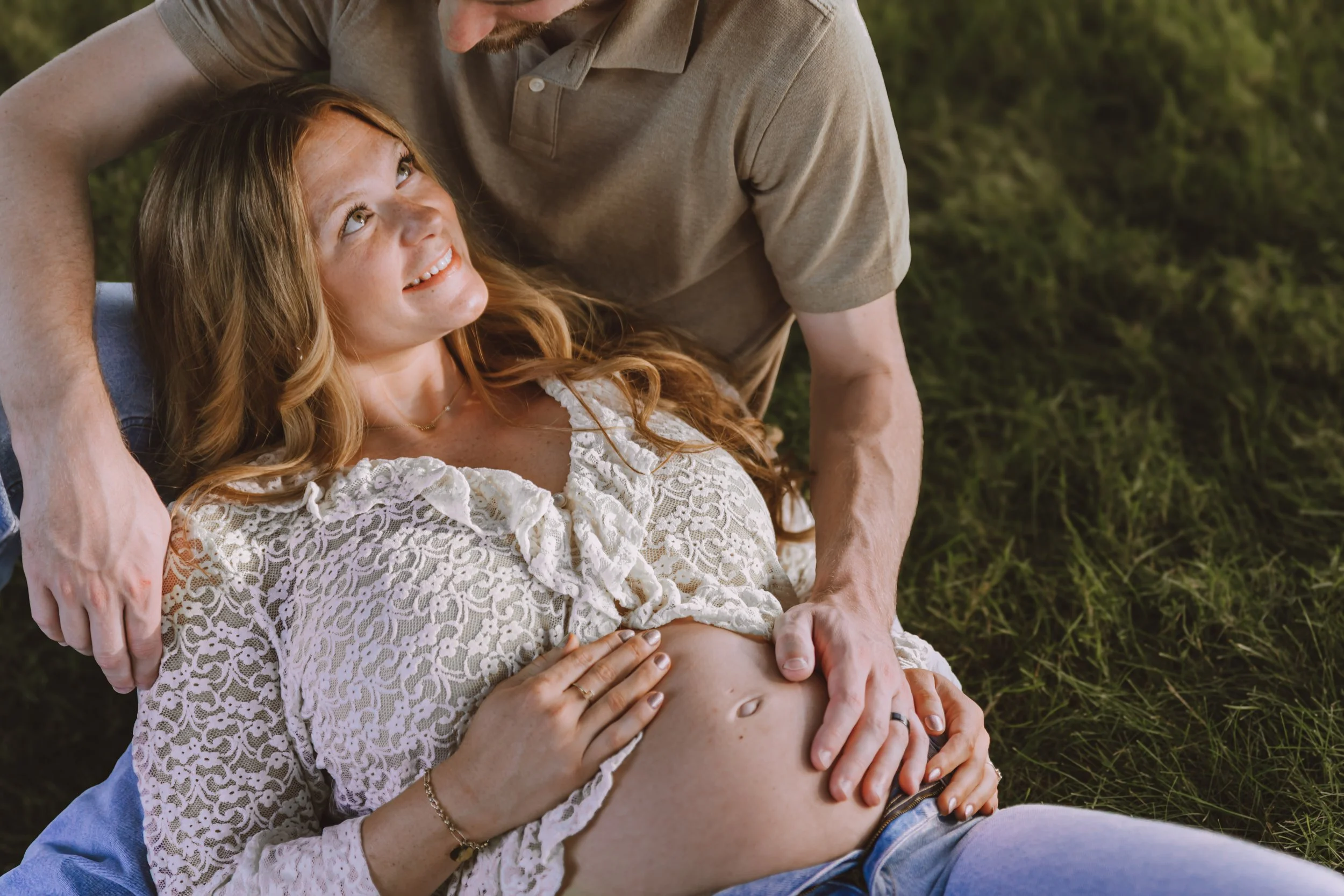 Expecting parents laughing together during an outdoor maternity photography session.