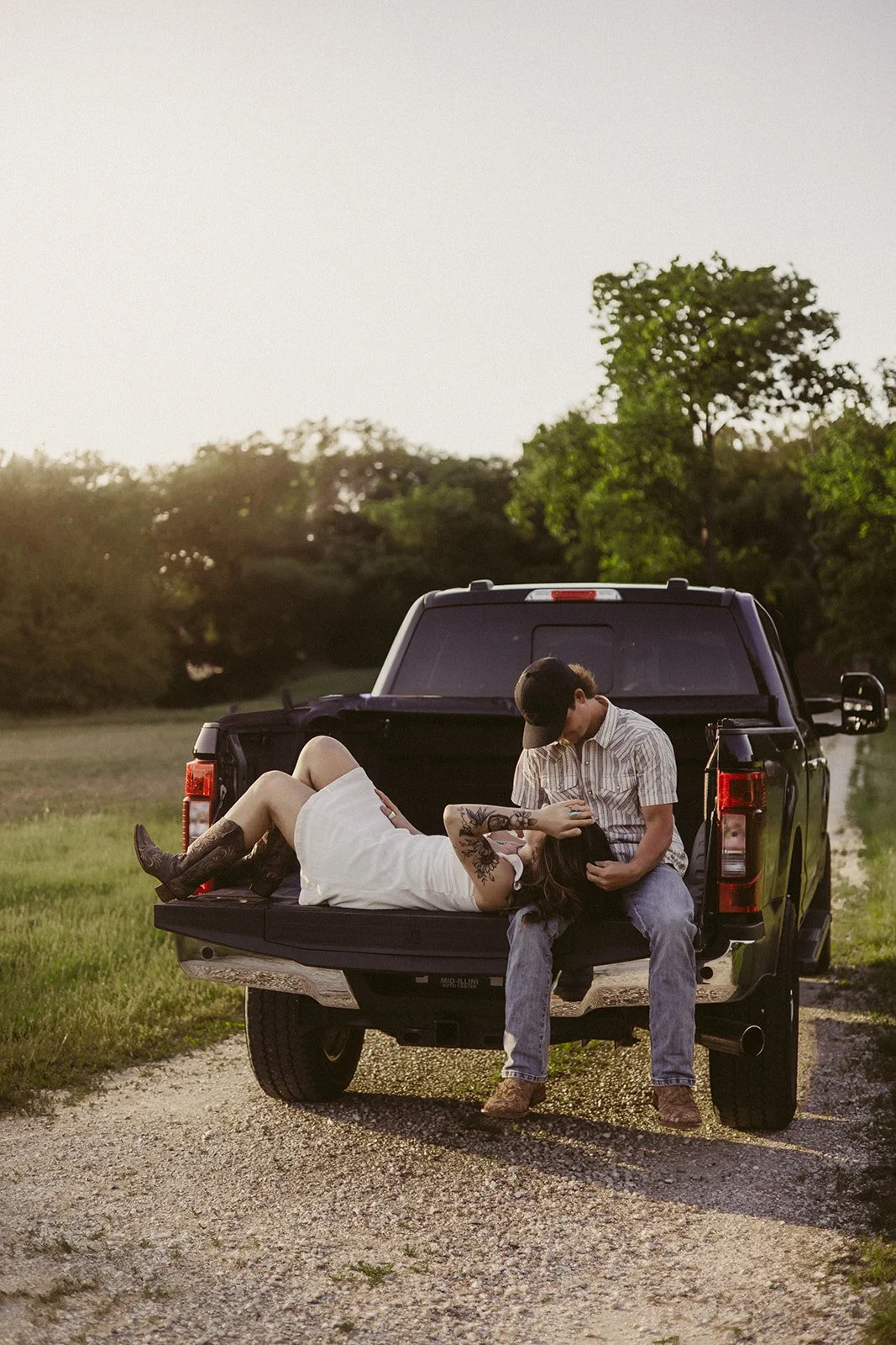 Couple cuddling in pickup truck cab with warm sunset light