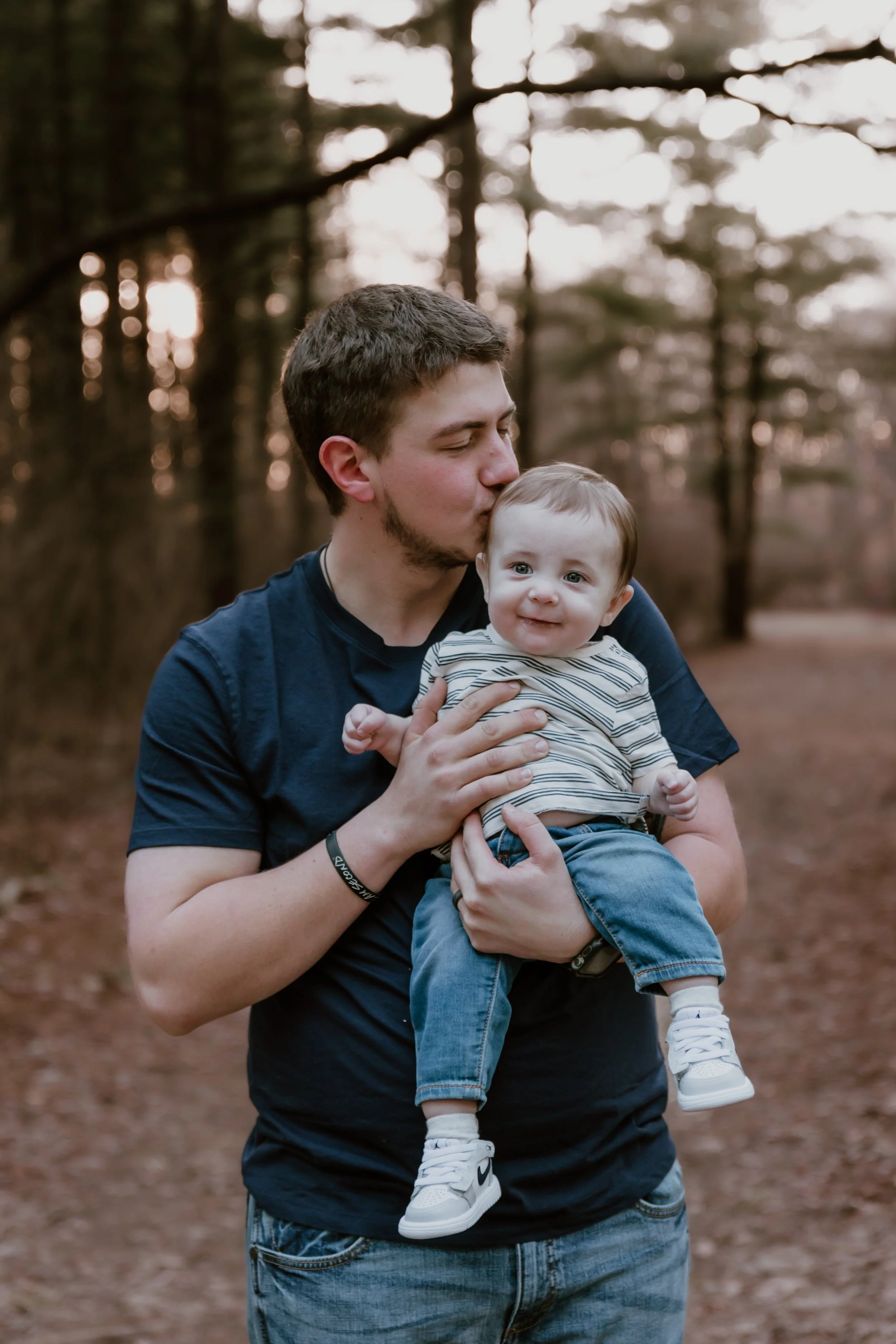 Parents holding baby during sunset family photos in Central Illinois
