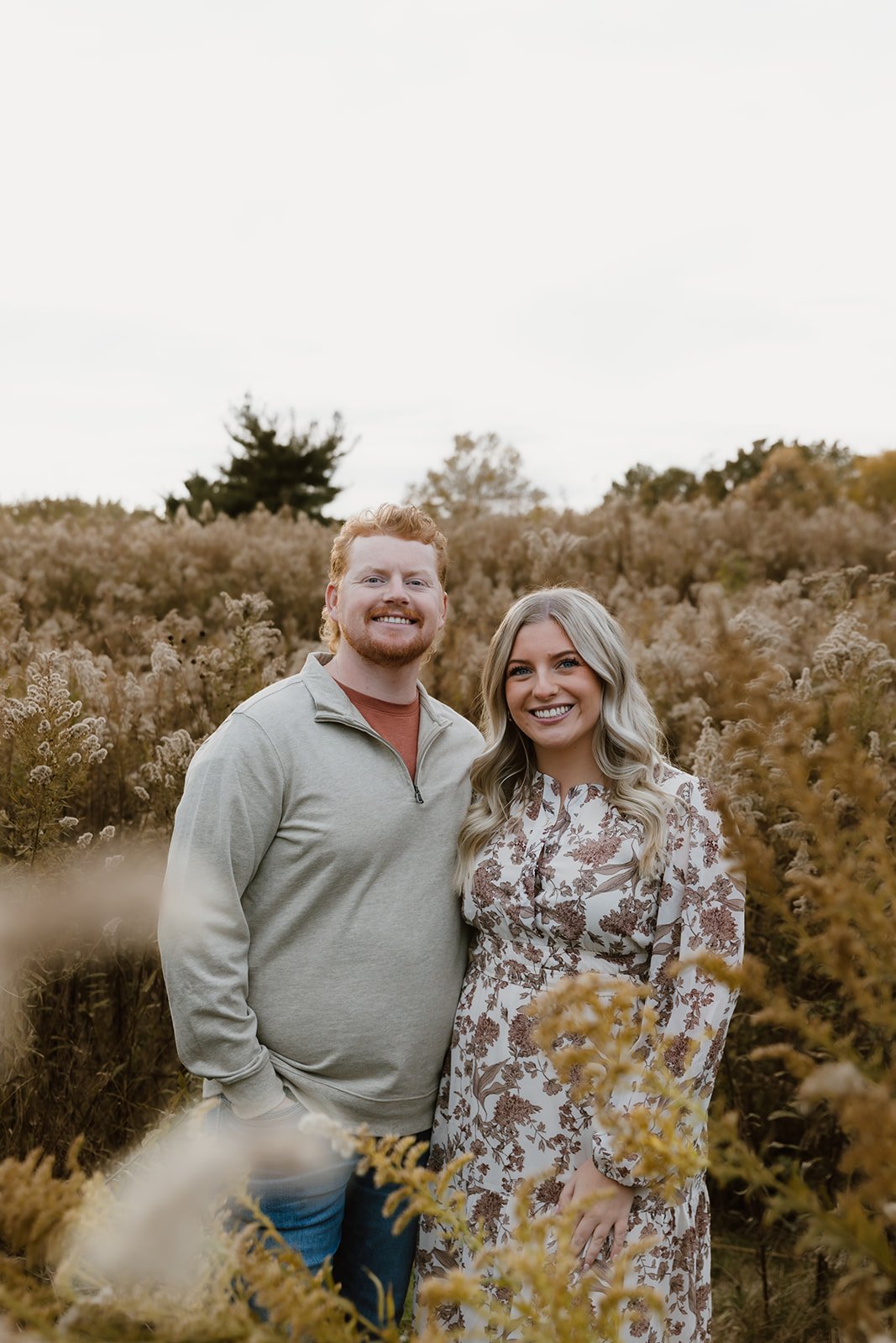 Couple embracing in tall grasses during sunset couples photos
