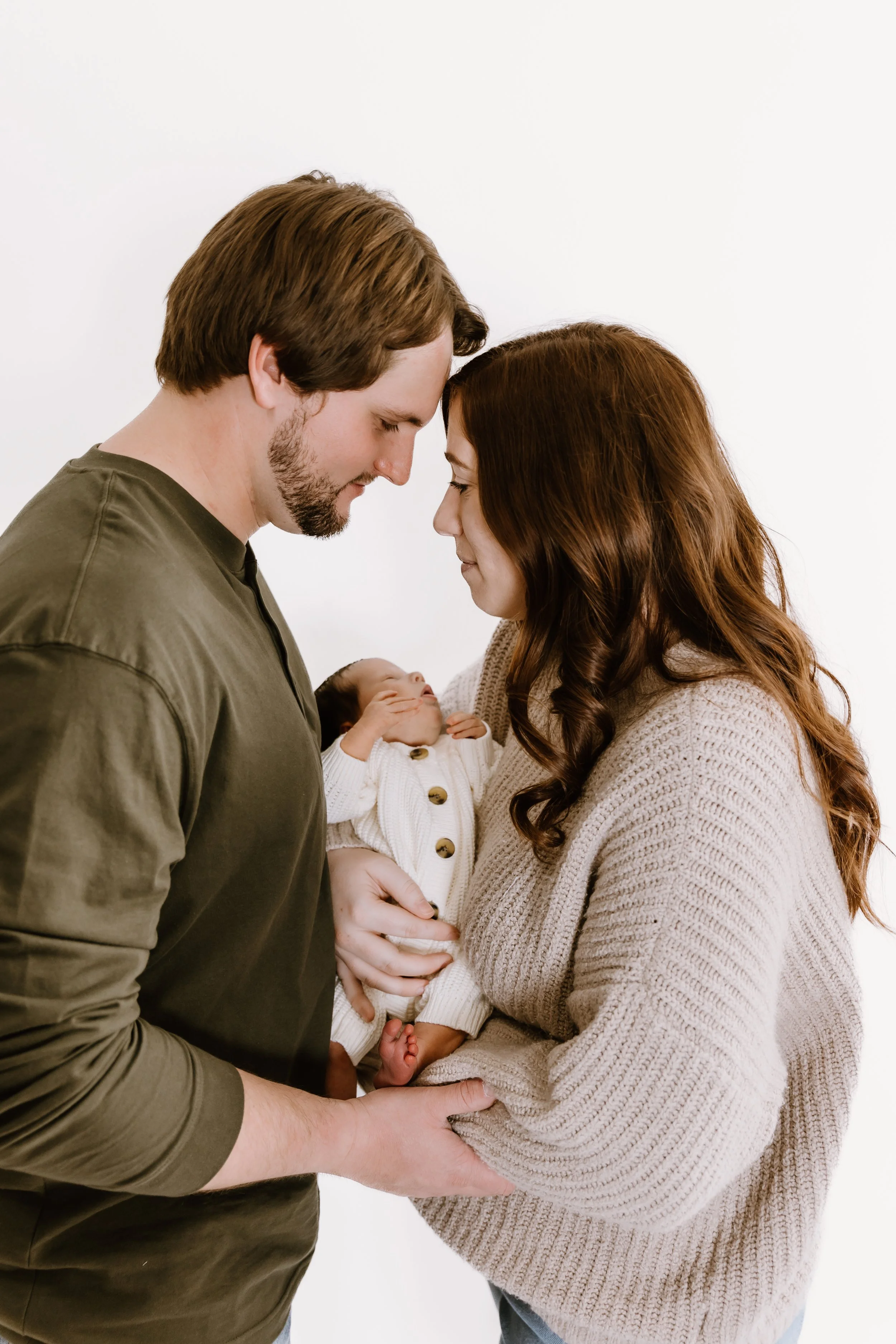 parents holding newborn baby family portrait