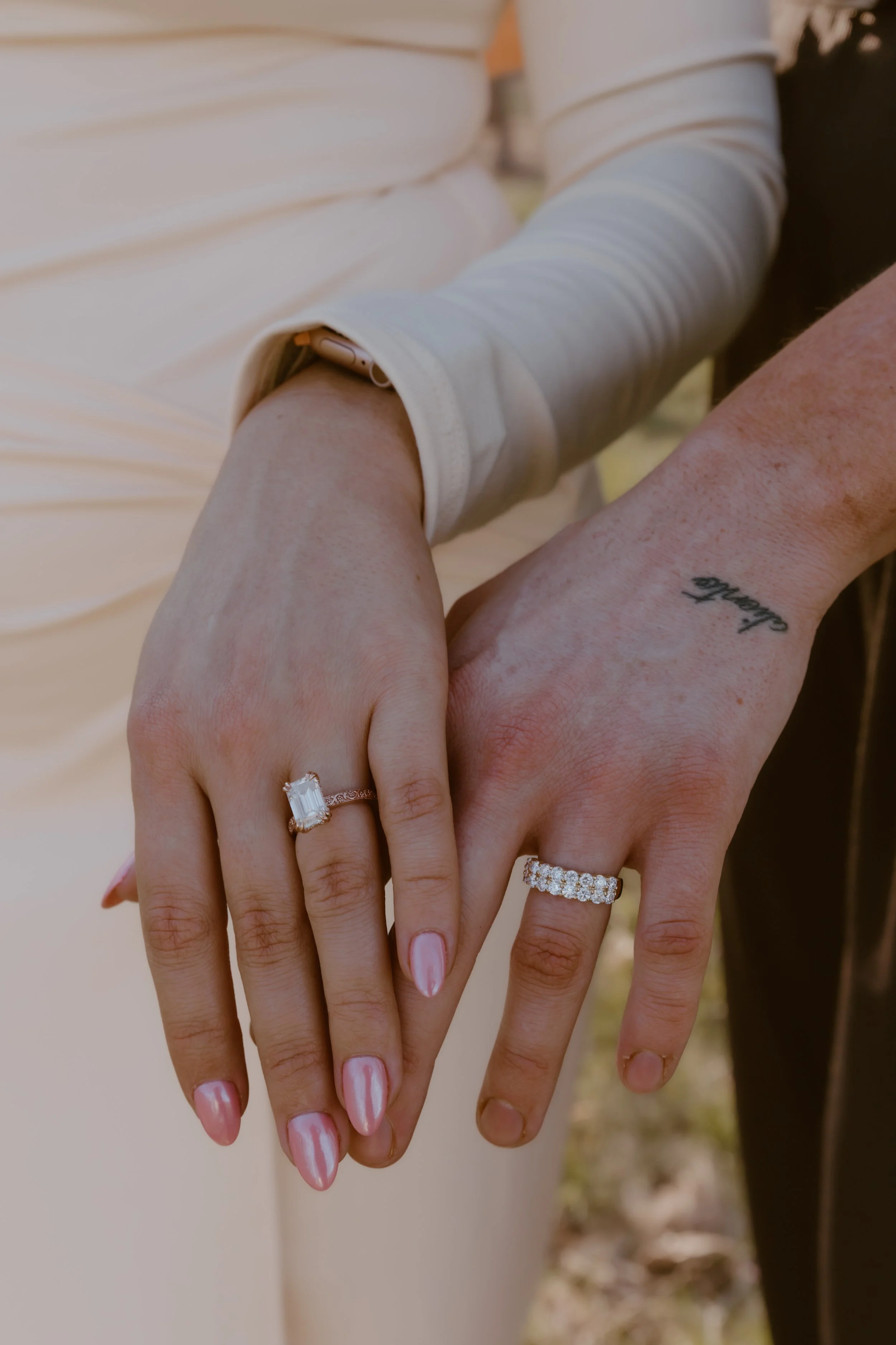 engagement ring close up on both partners hands outdoors