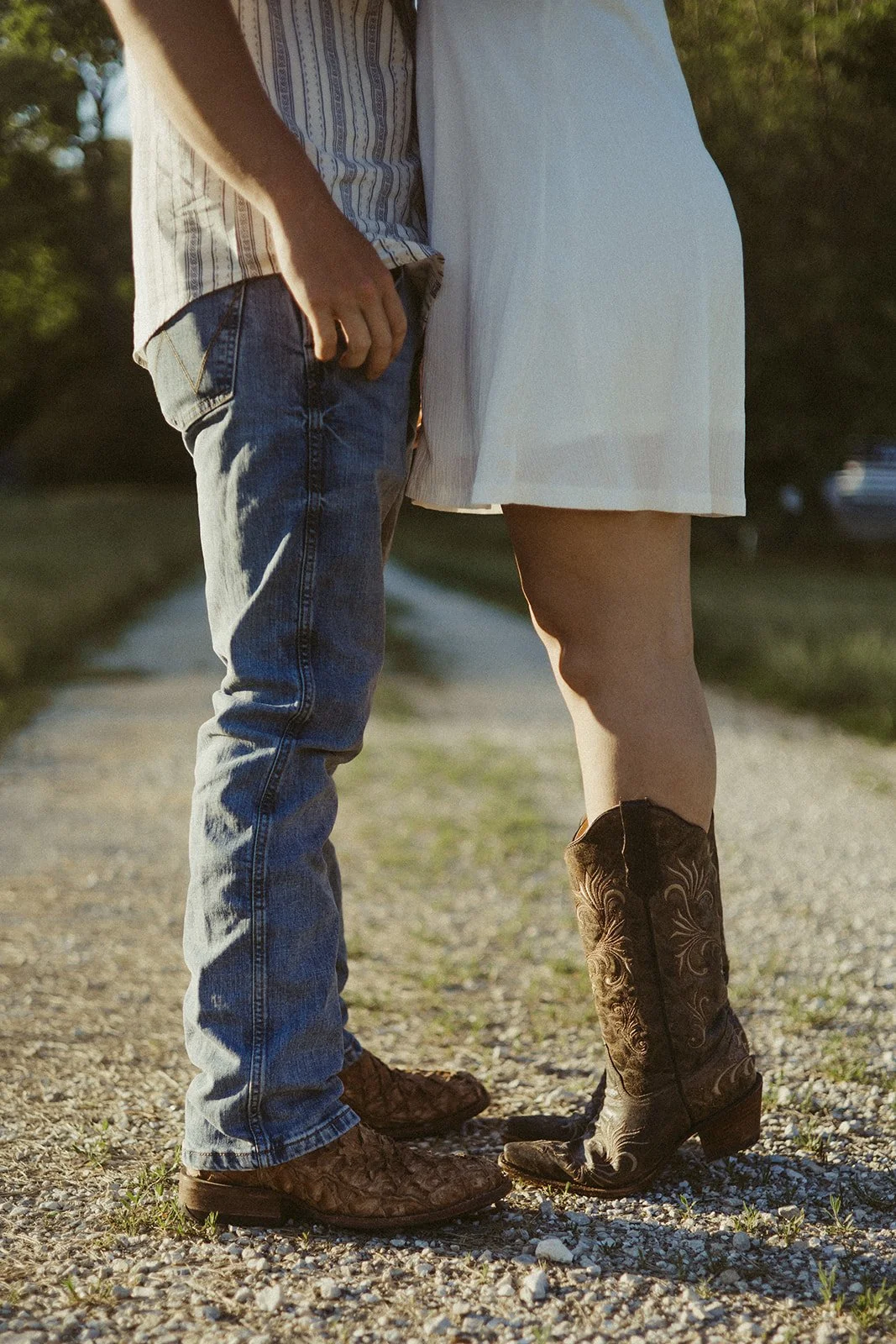Couple kissing in front of rustic wooden barn during country couples photoshoot