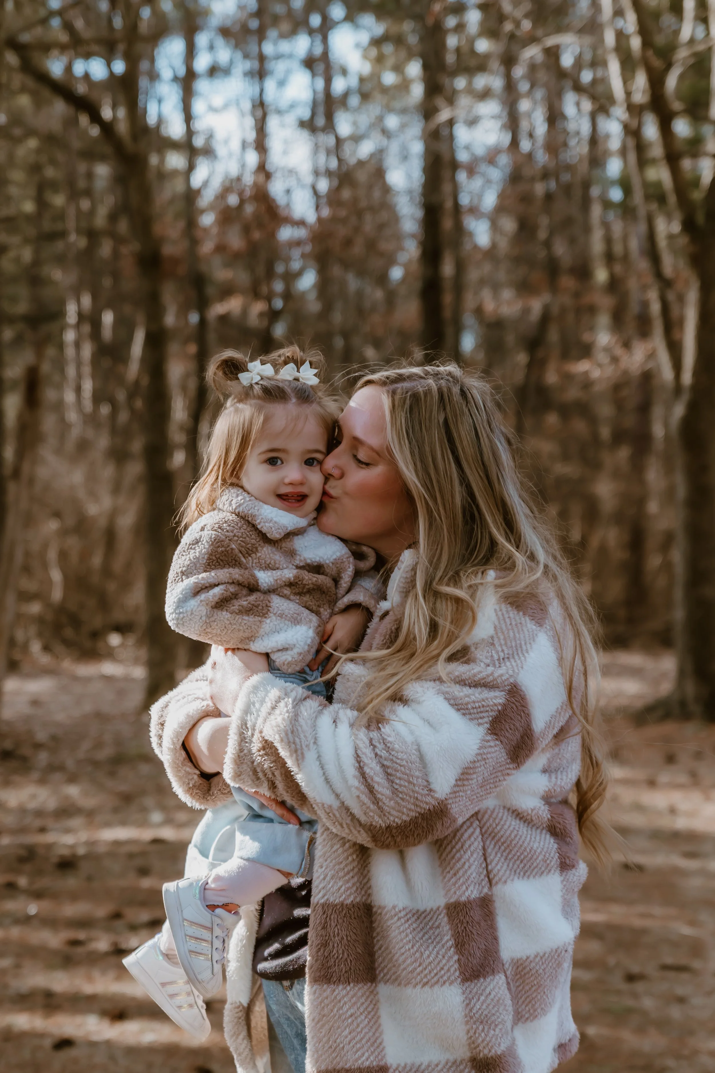 Natural family photography in pine trees with a mom, toddler, and dog in Illinois