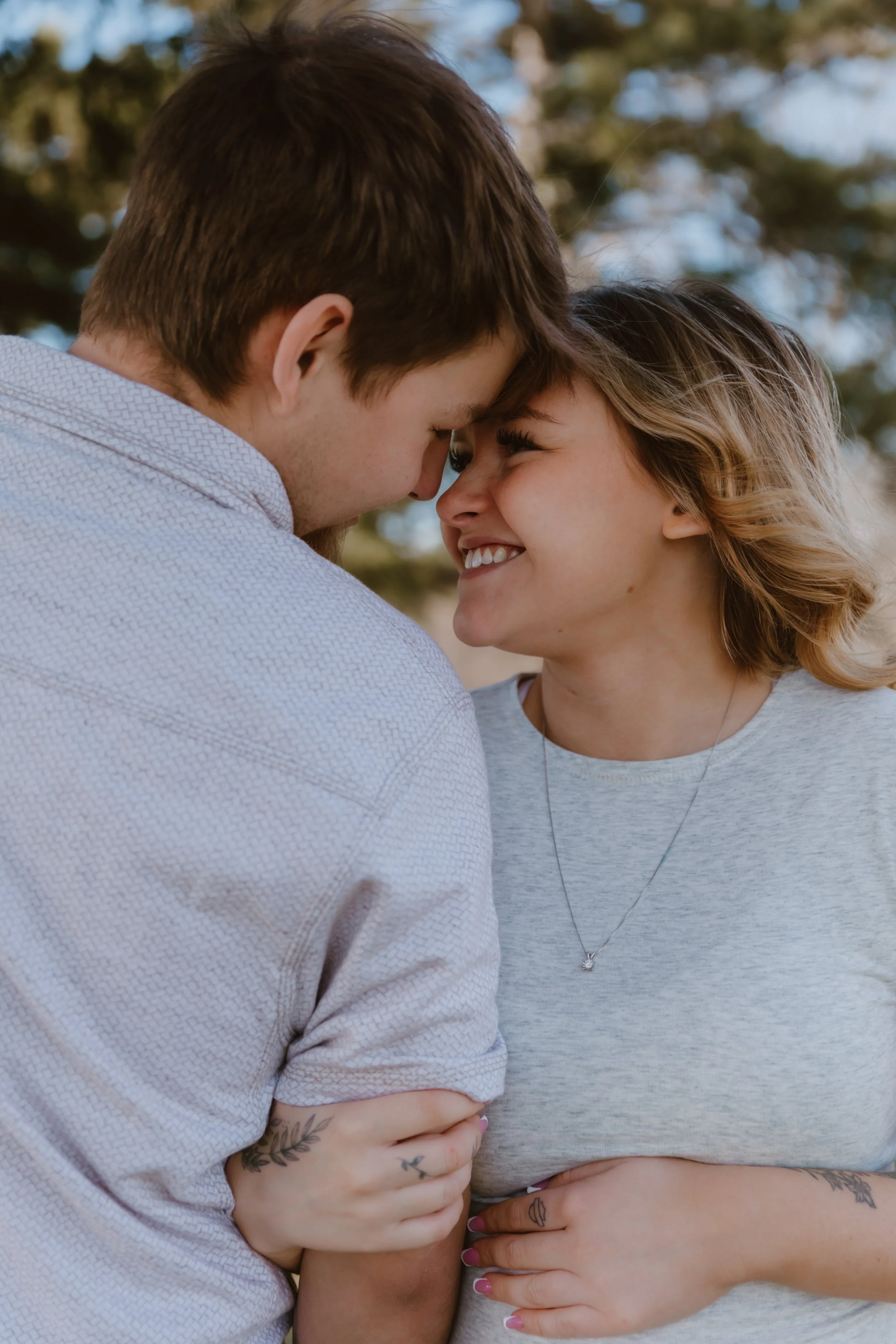 close up of couple smiling forehead to forehead maternity session outdoors