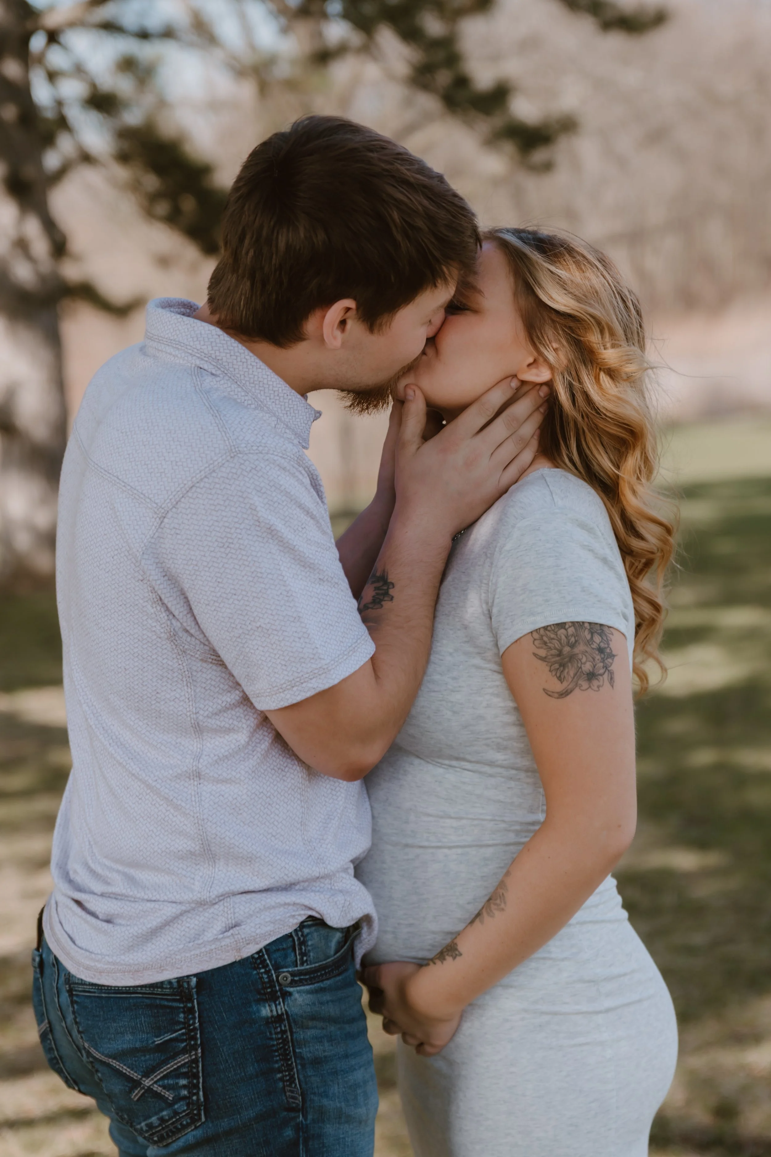 couple kissing during spring maternity session peoria illinois