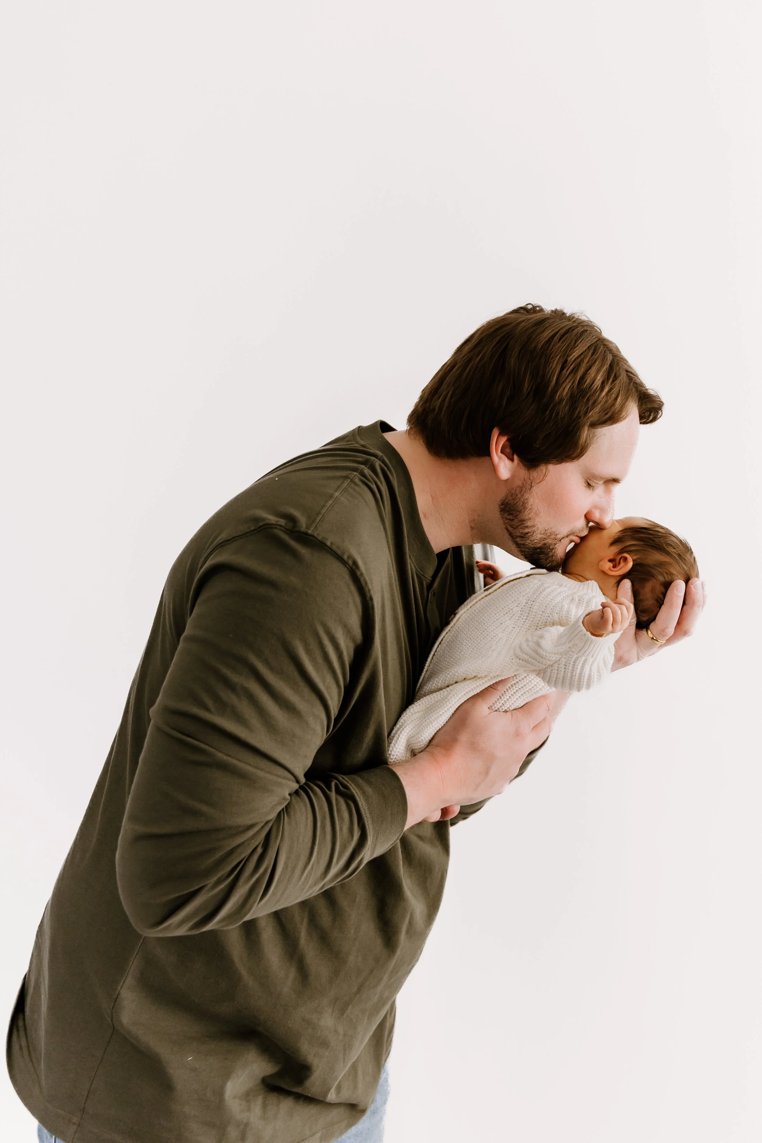father holding newborn baby boy portrait