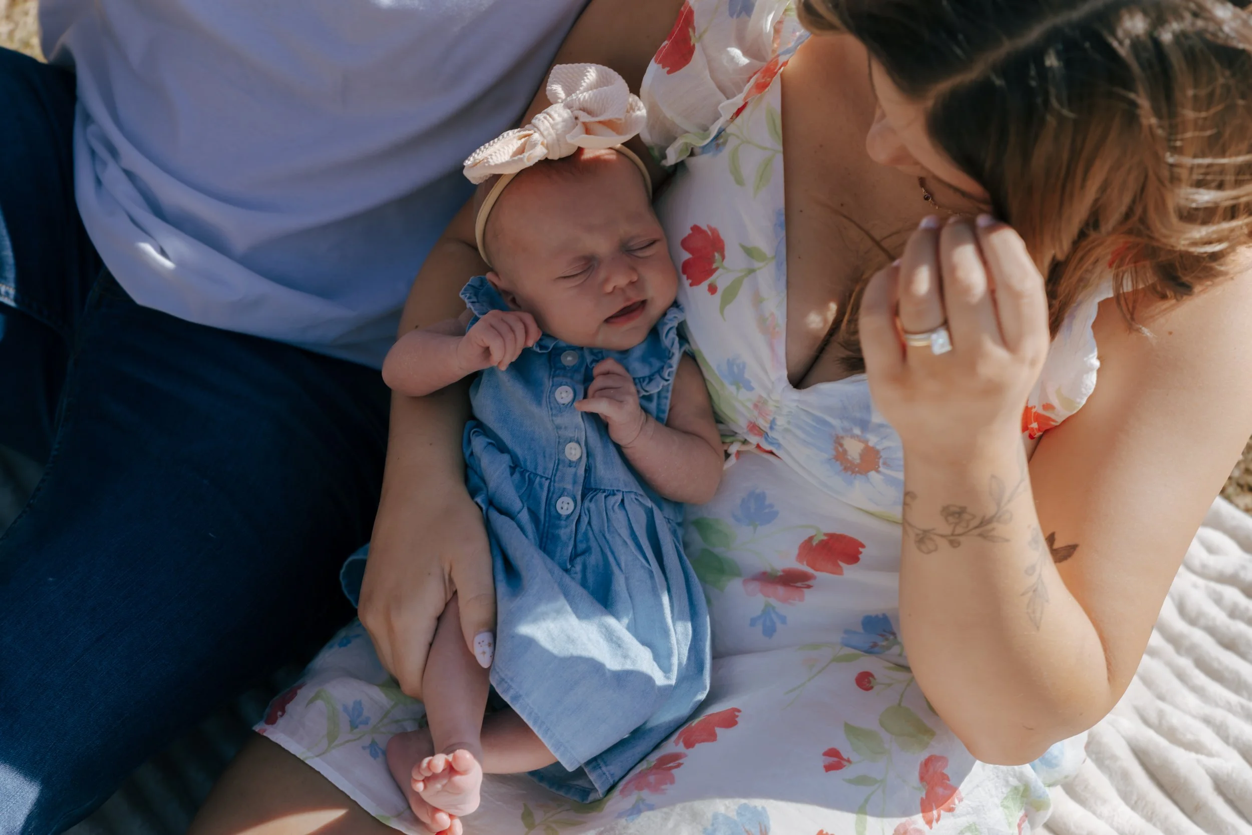 Parents holding newborn together by the lake during family photos in Eureka Illinois