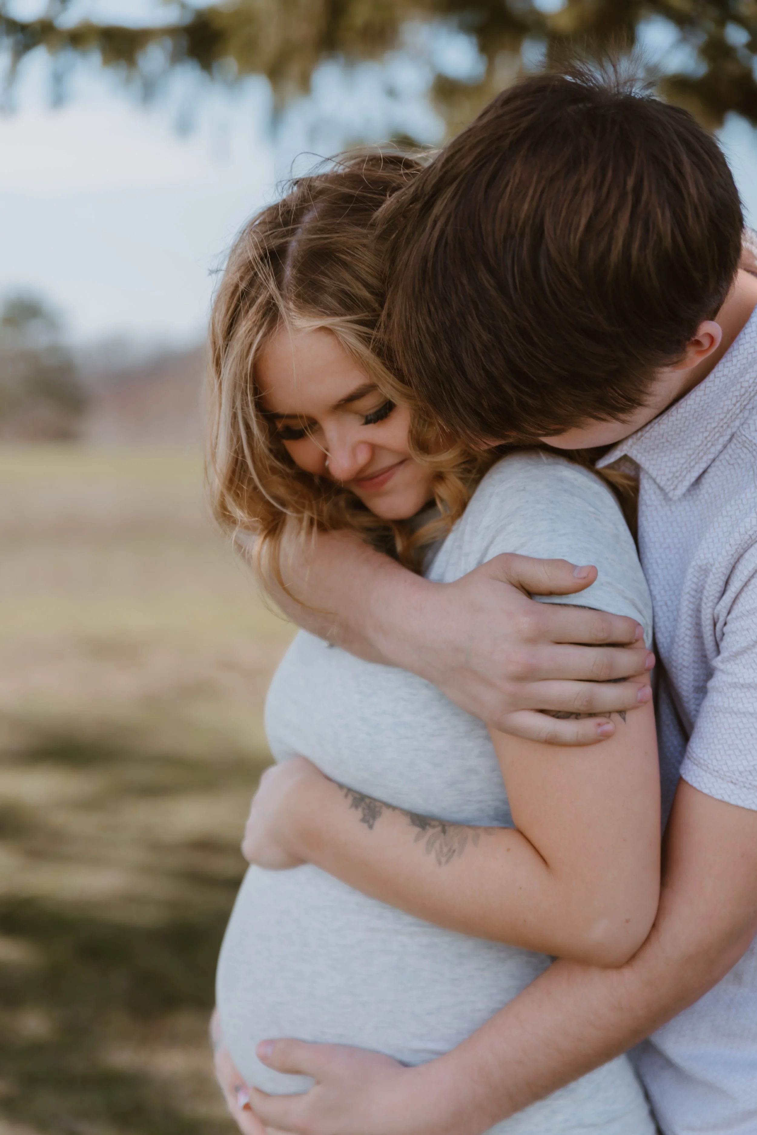 intimate close up of couple smiling during outdoor maternity photos