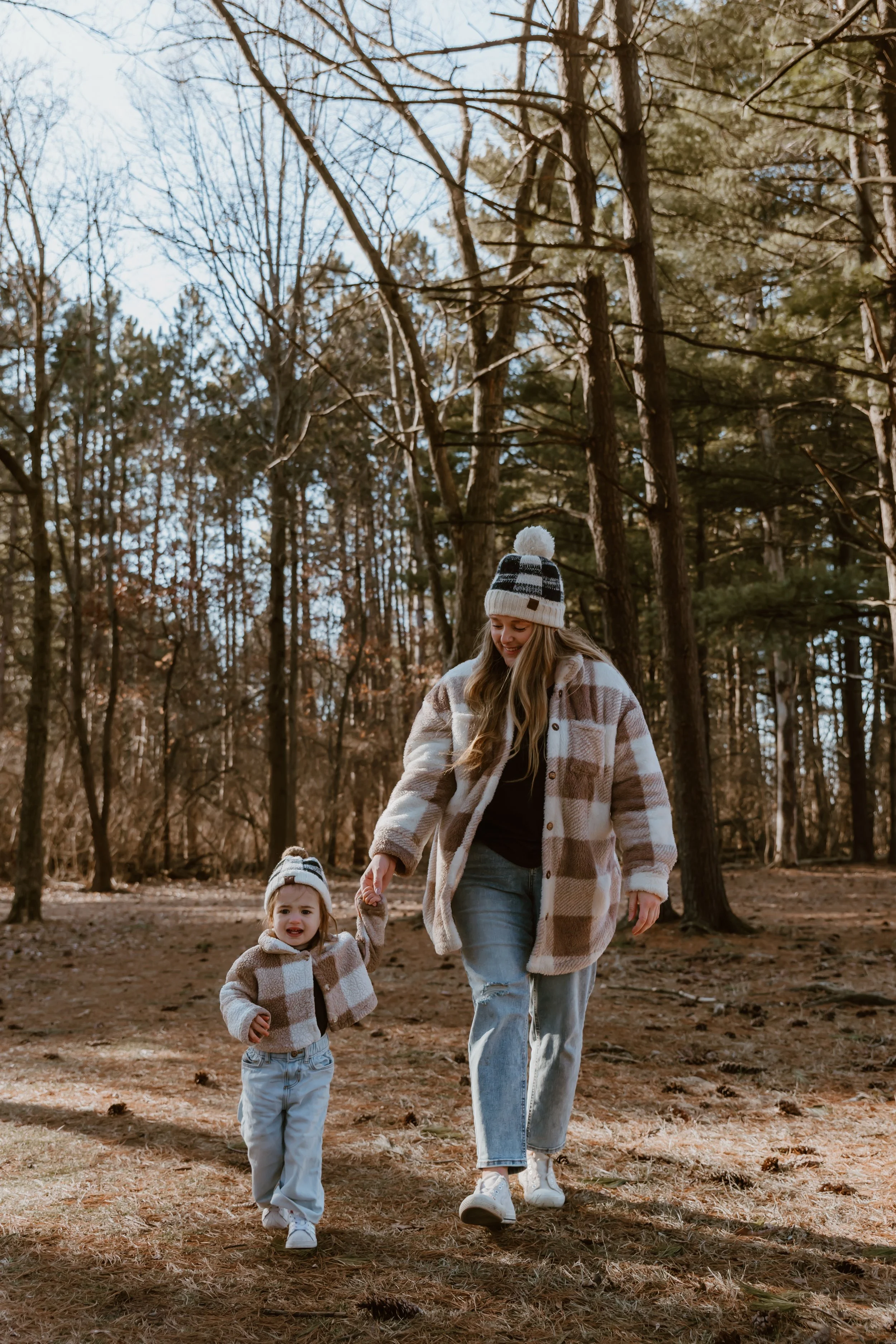 Toddler cuddling into mom during a cozy winter family session in East Peoria, Illinois