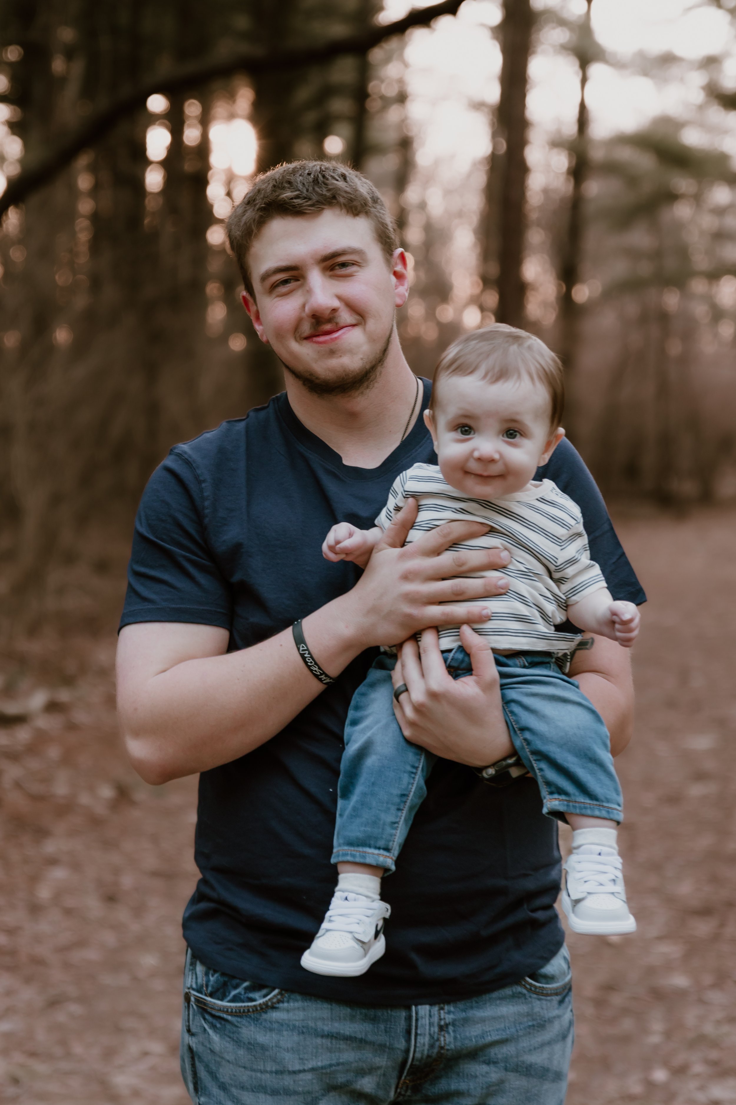 east peoria photoshoot of family. dad holding baby during golden hour