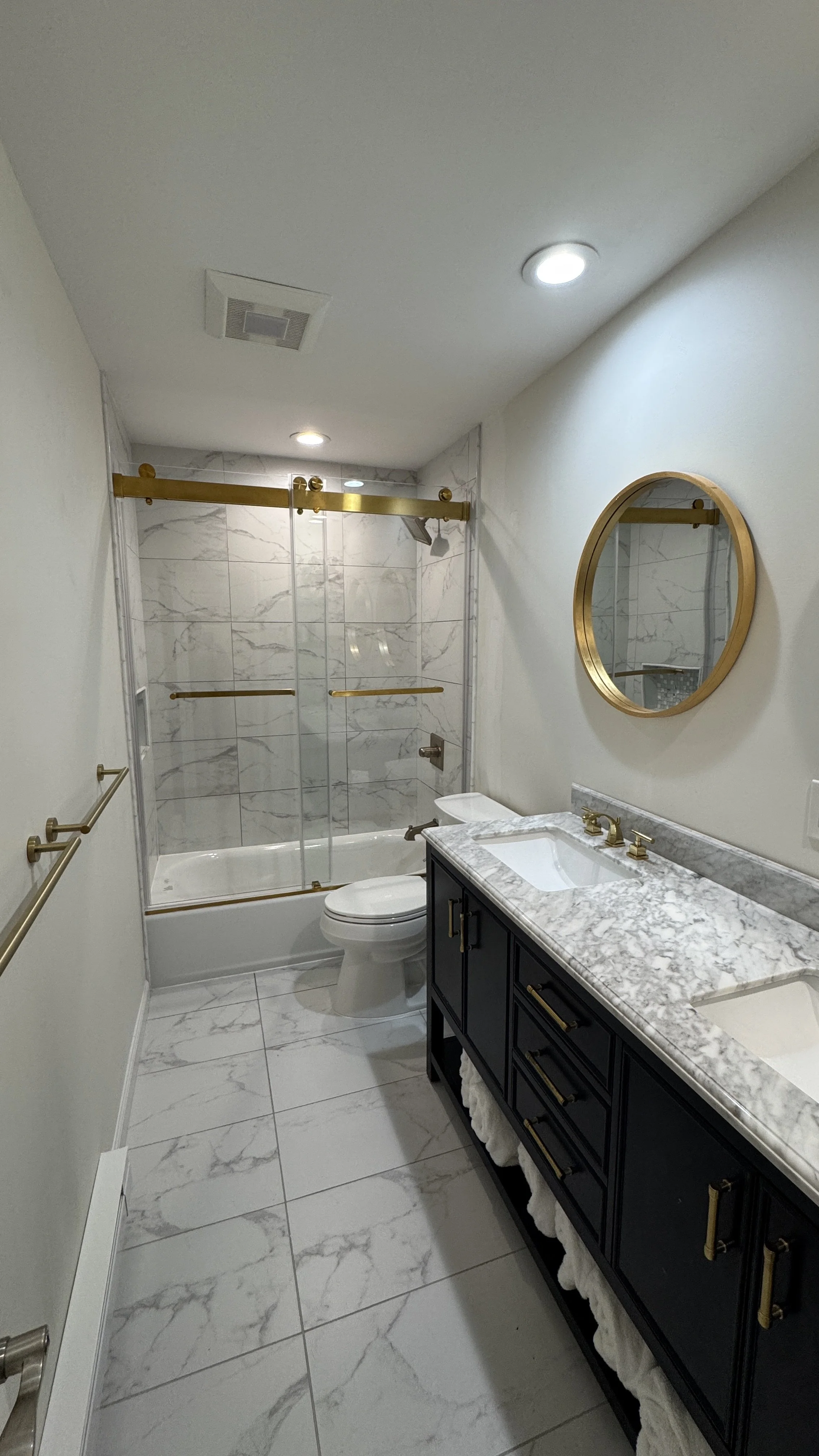 High end bathroom renovation Westchester County NY with marble tile, custom vanity, glass shower, and spa like finishes by expert remodelers.