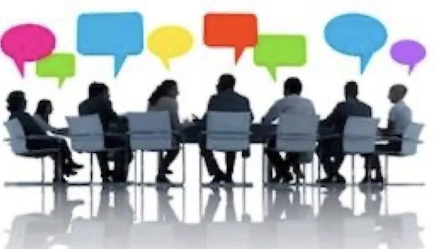 Silhouettes of people seated around a conference table with colorful speech bubbles above them, suggesting discussion or collaboration.
