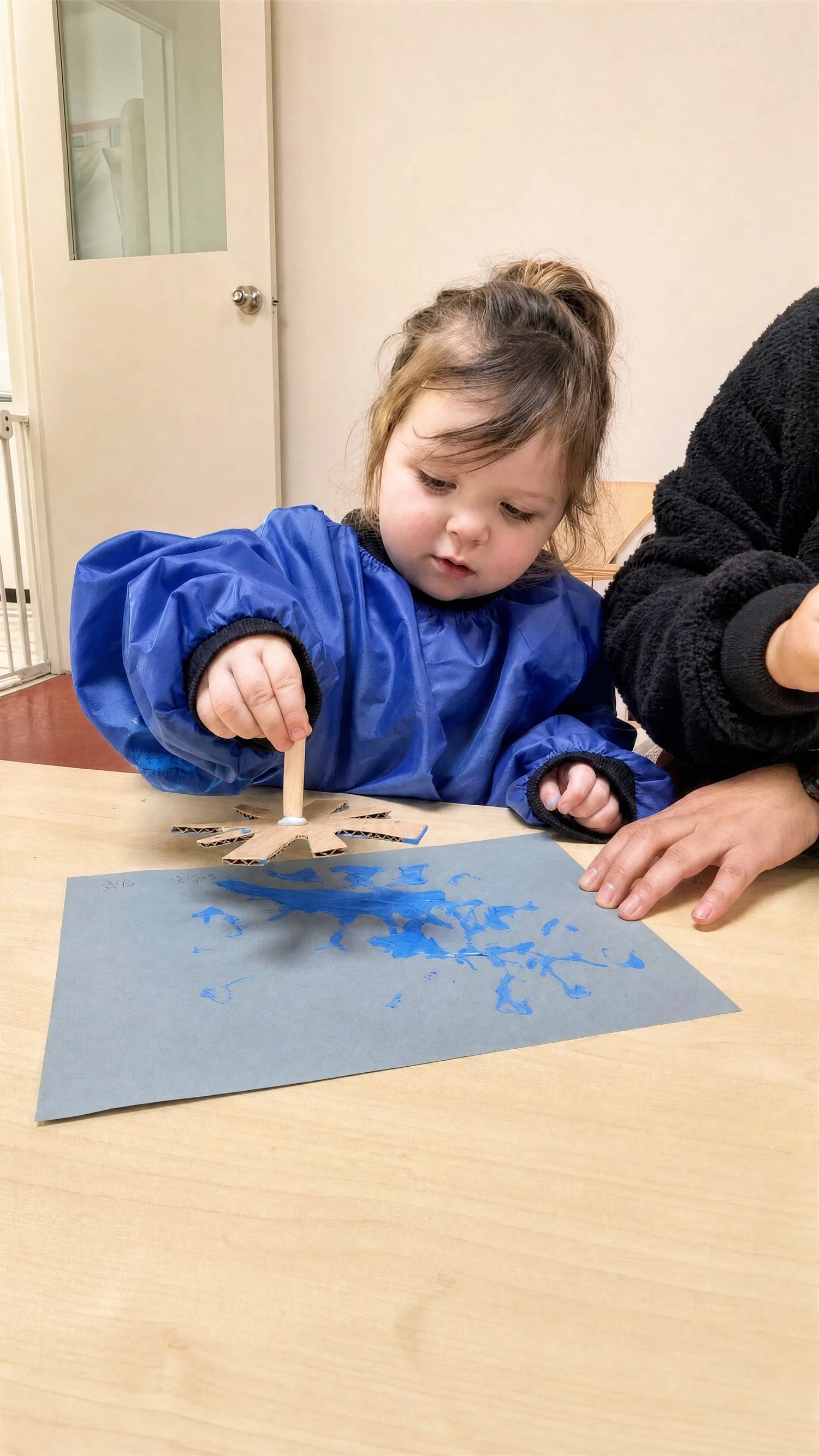 Toddler painting at the art table during a casual day