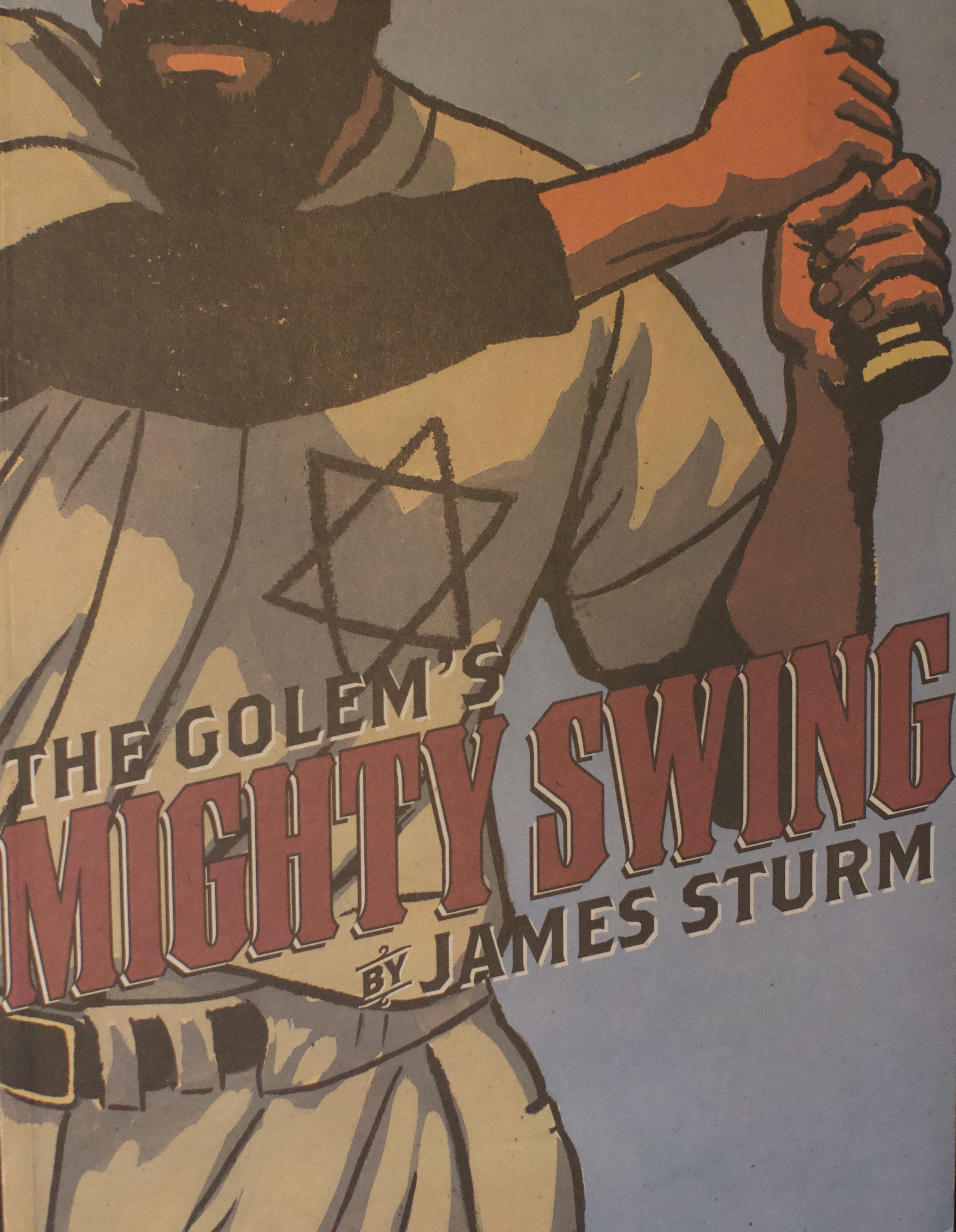 A close-up image of the cover of a graphic novel titled "The Columbian" by James S. Ullum. The cover features an illustrated figure with an open hand, wearing a beige shirt and a black sleeve, against a background with text and geometric design elements.