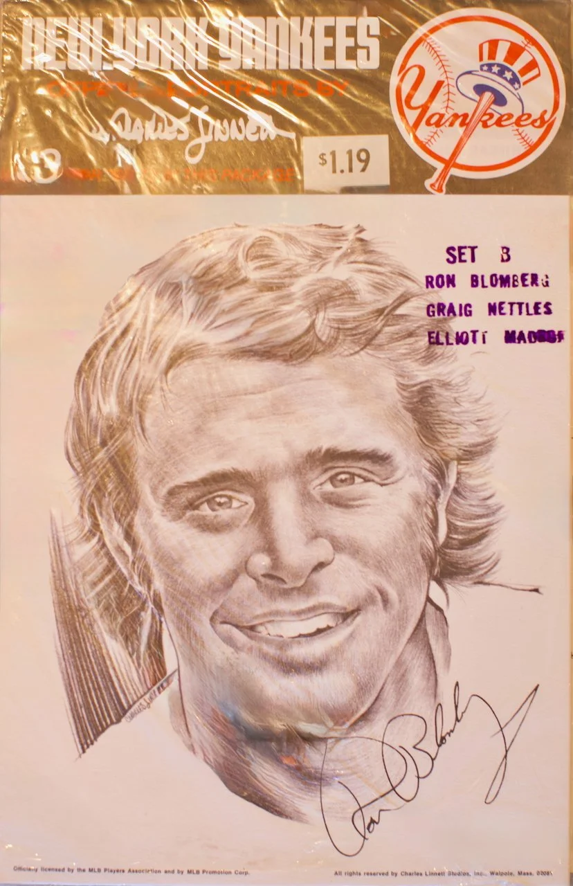 Black and white sketch of a smiling man with long, wavy hair, wearing a baseball uniform, signed by Charles Linne. Contains the Yankees logo, a list of names, and a price tag of $1.19.