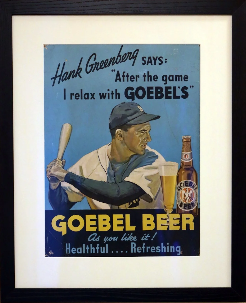 Vintage framed advertisement for Goebel Beer featuring a baseball player holding a bat, with a glass of beer and a bottle of Goebel Beer, and text promoting the beer as healthy and refreshing.