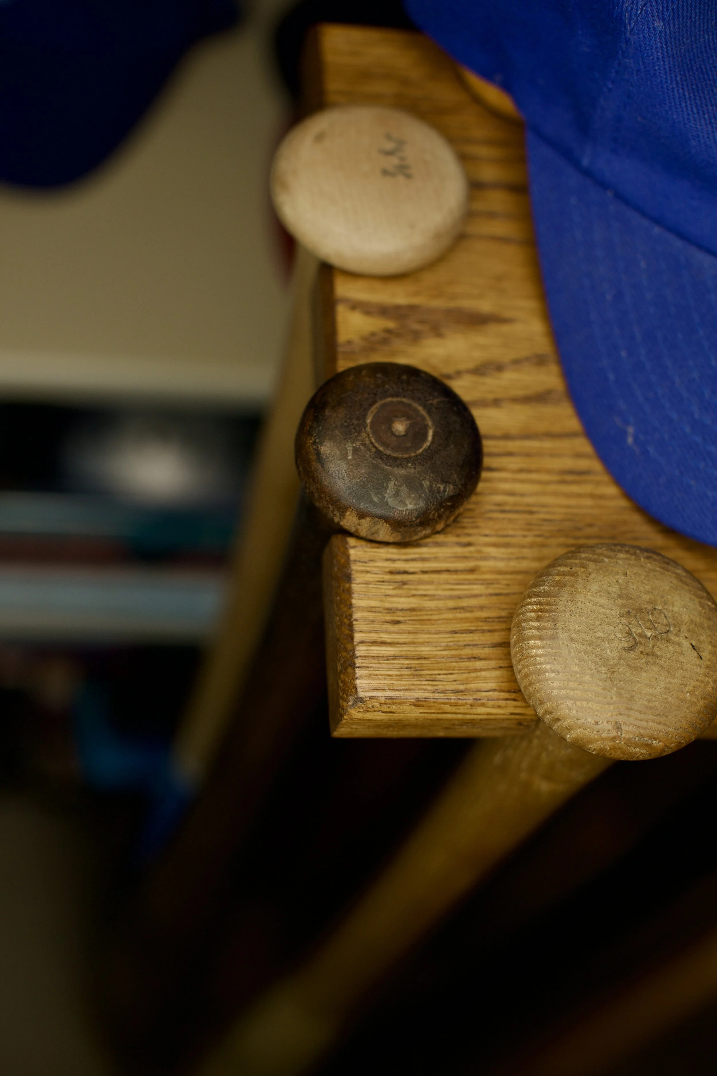 Close-up of the heads of several wooden furniture legs with different colors and shapes, resting on a wooden surface.