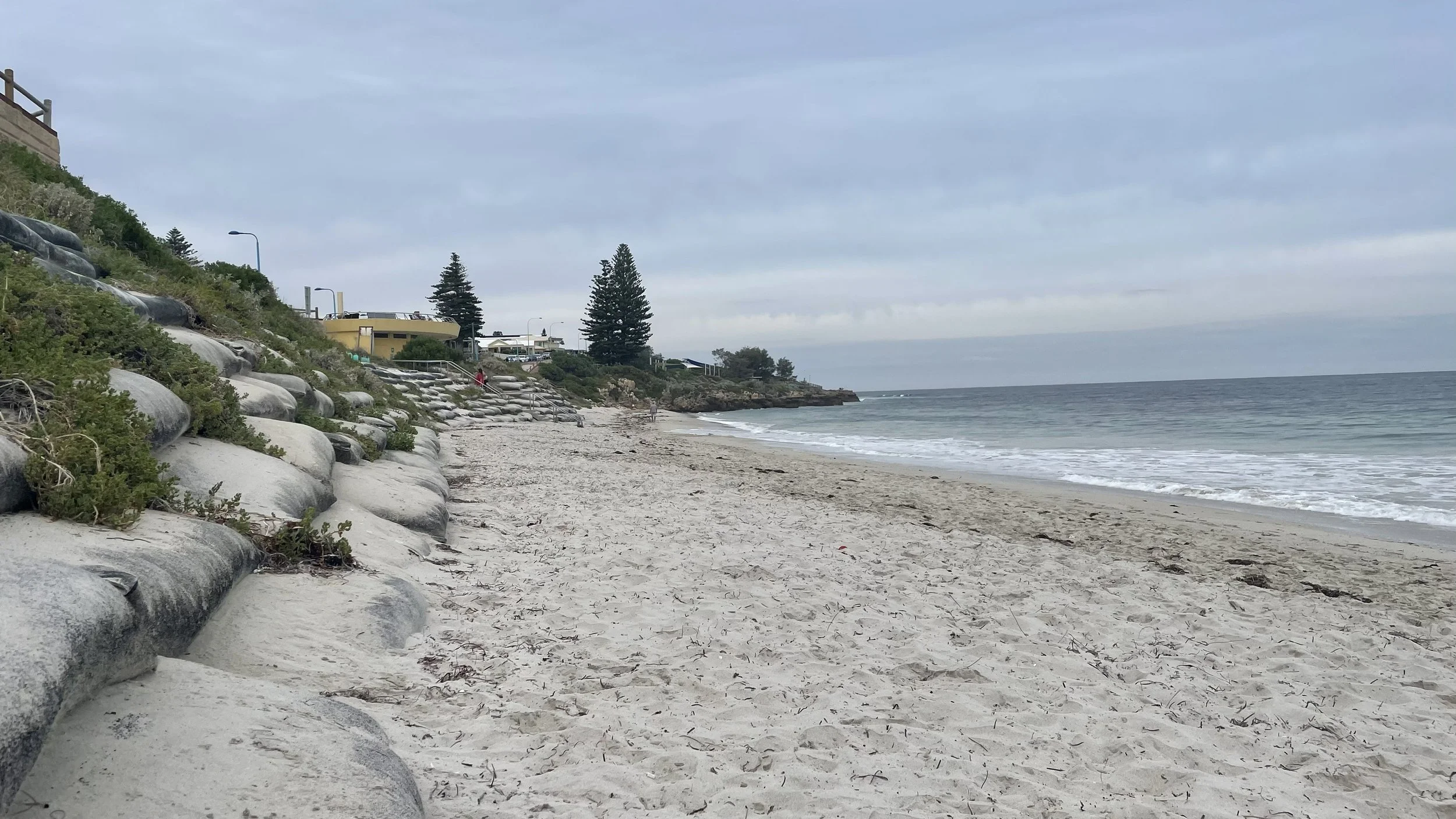 Photo of a beach with sandbags to the left of the beach (aka pillows)