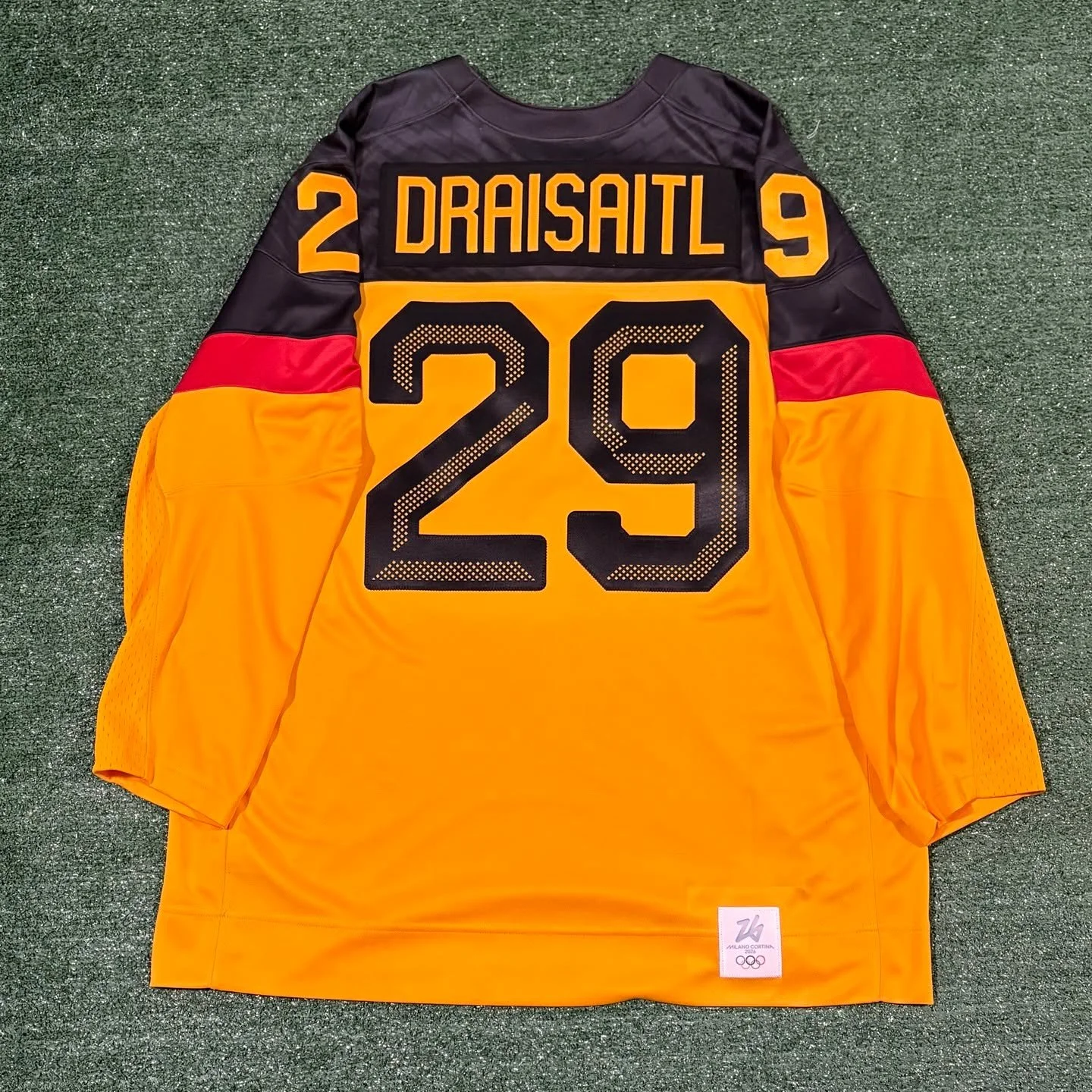 Leon Draisaitl Team Germany Olympics Jersey

Even though the jerseys with the official crests (or the dark jerseys) weren&rsquo;t available at retail, I still had to pick one up. The colors are just too nice! The perforated beveling pattern in the nu