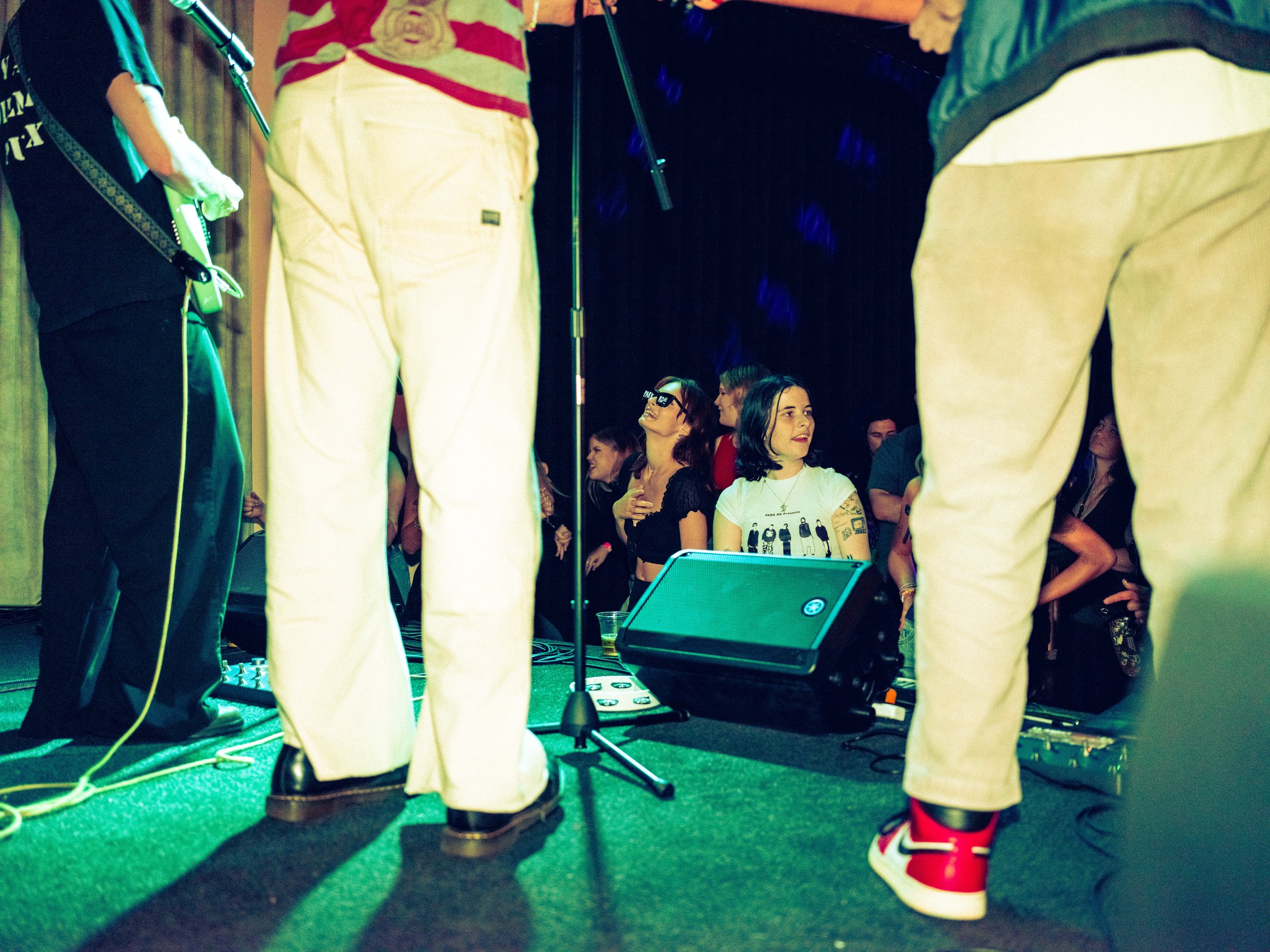 People standing on stage at a concert or event, taken from a low angle.