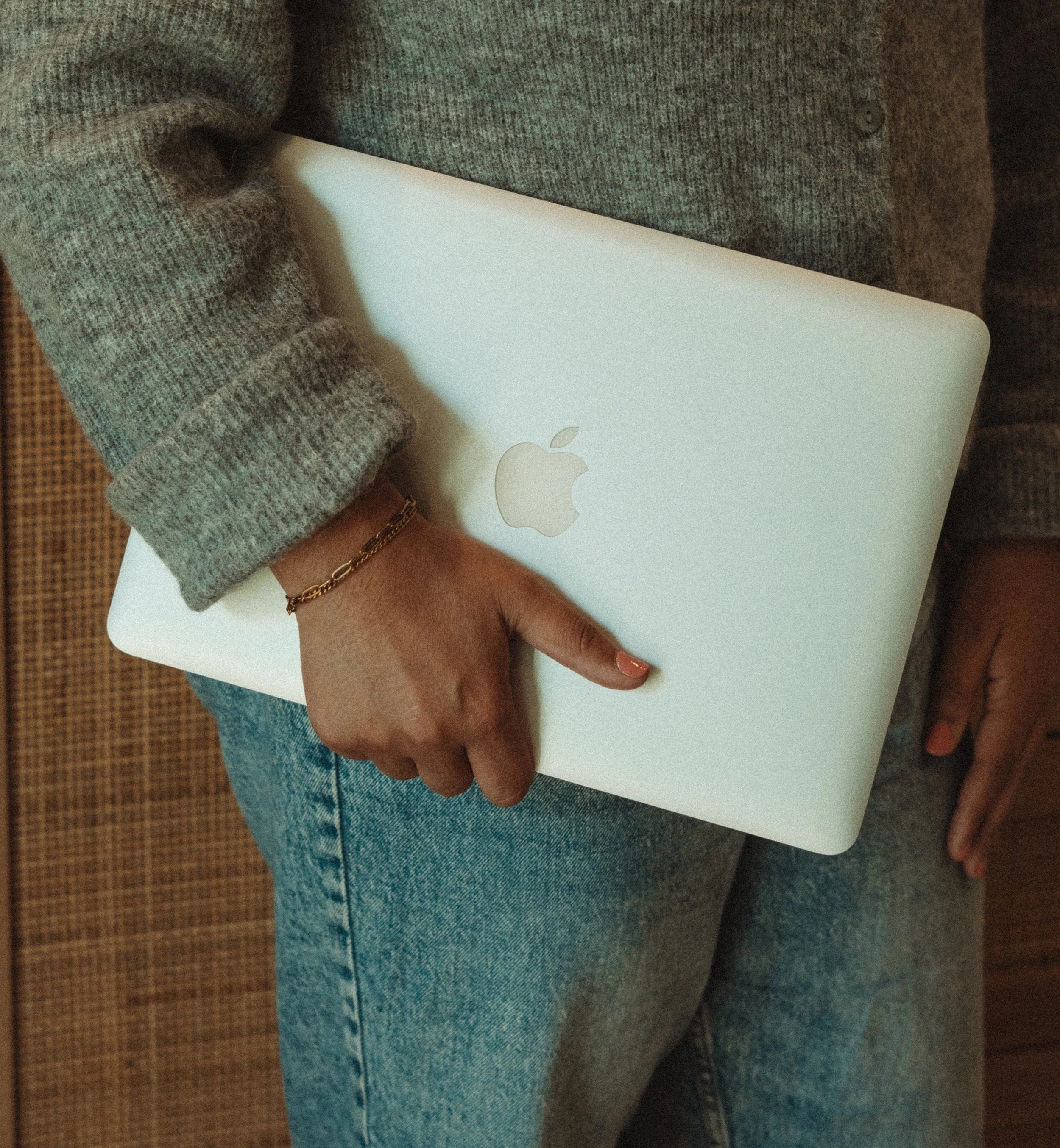 woman holding laptop at her hip