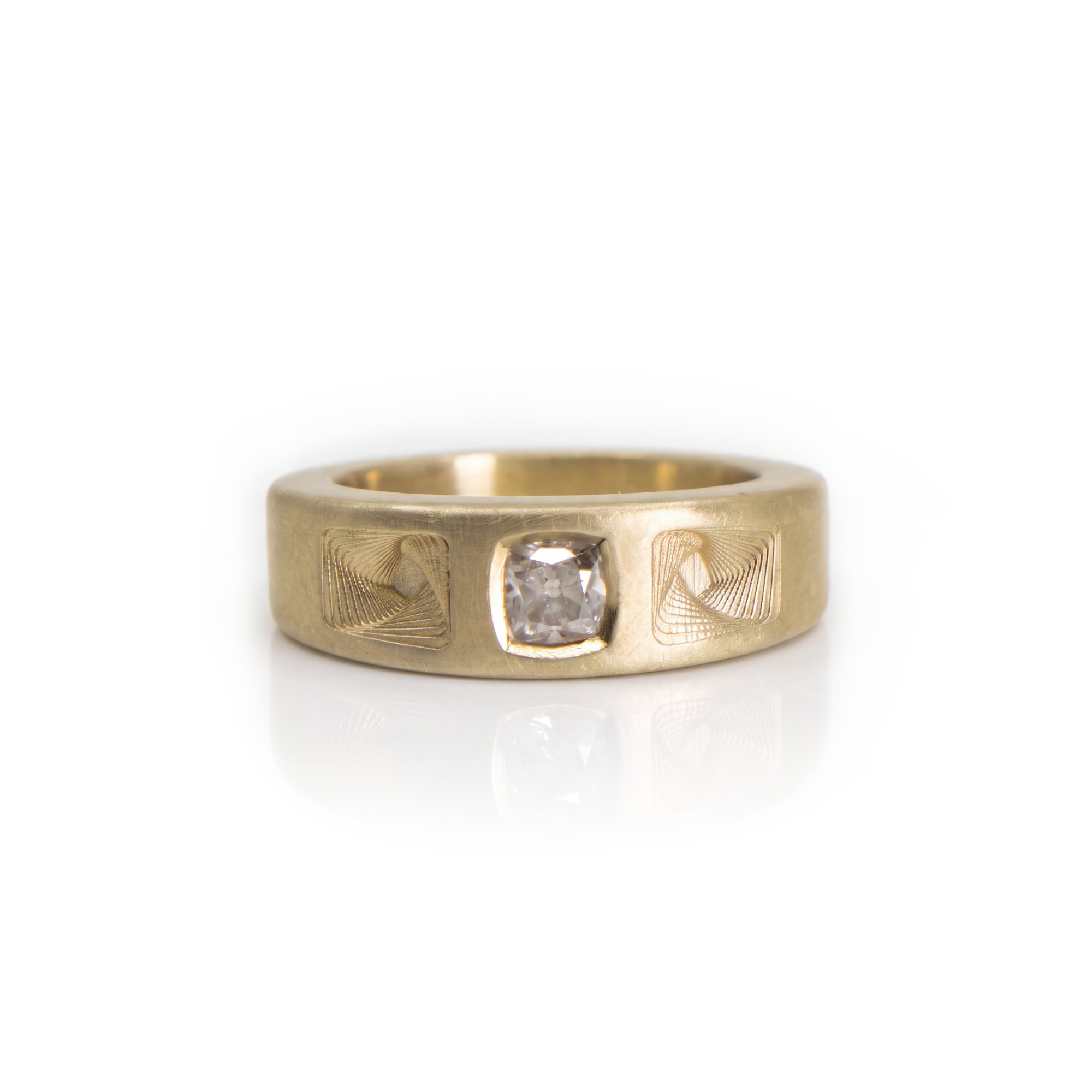 A silver ring with a rectangular face featuring a large teardrop-shaped yellow gemstone and two smaller accent stones, with engraved lines on the face.