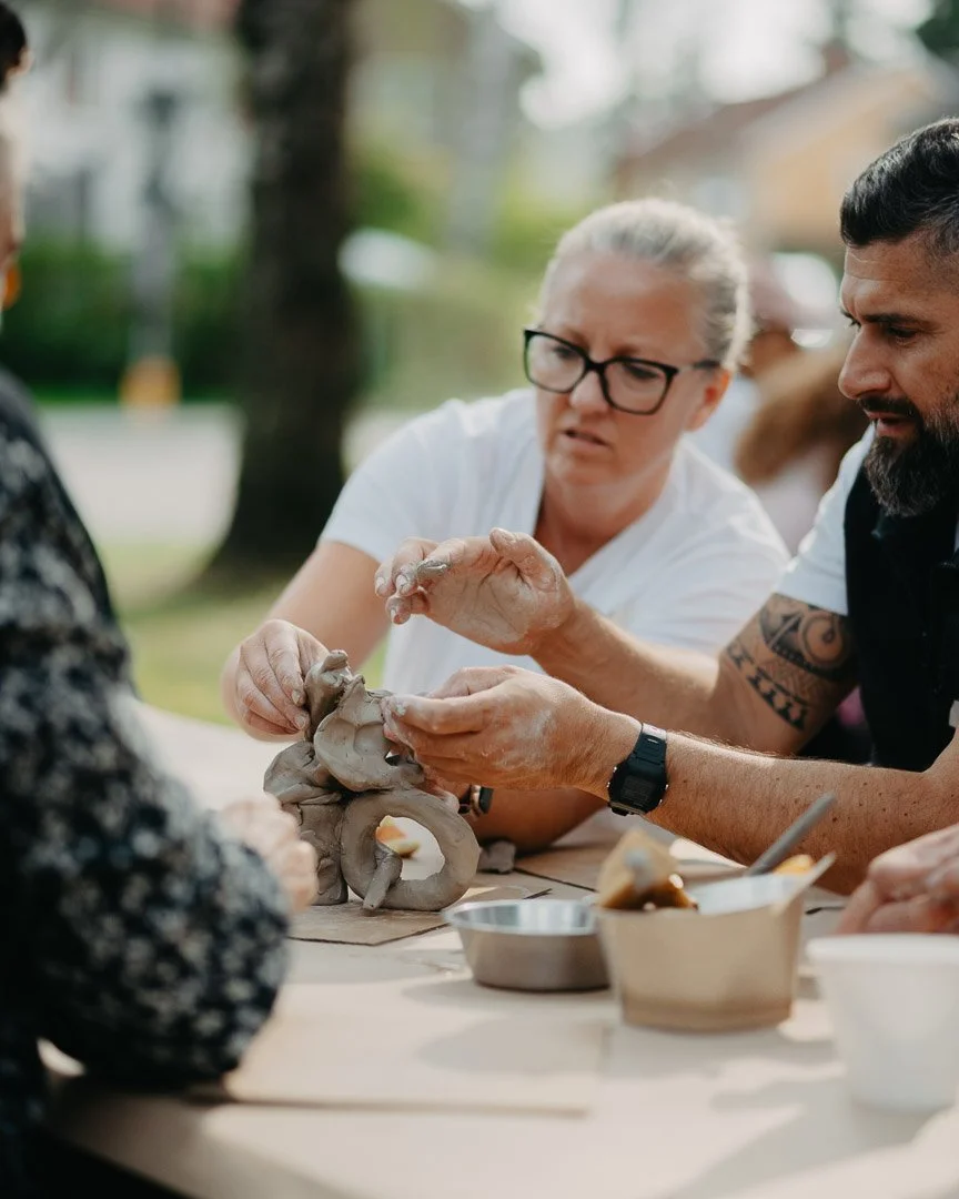 Personer som arbetar med ett modellarbete av en keramisk skulptur utomhus.