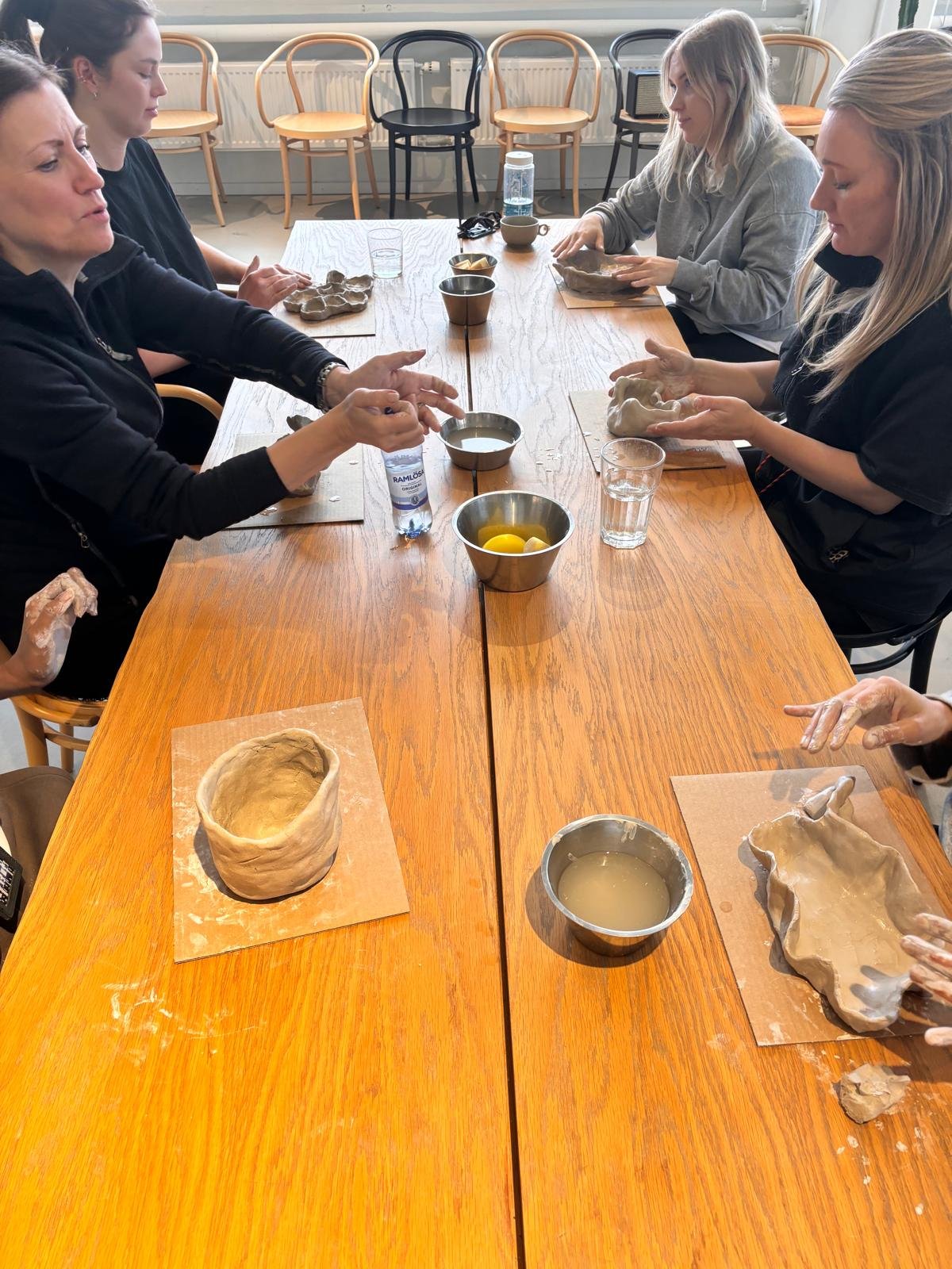 Människor som gör intuitiv skulptering vid ett bord i ett rum.