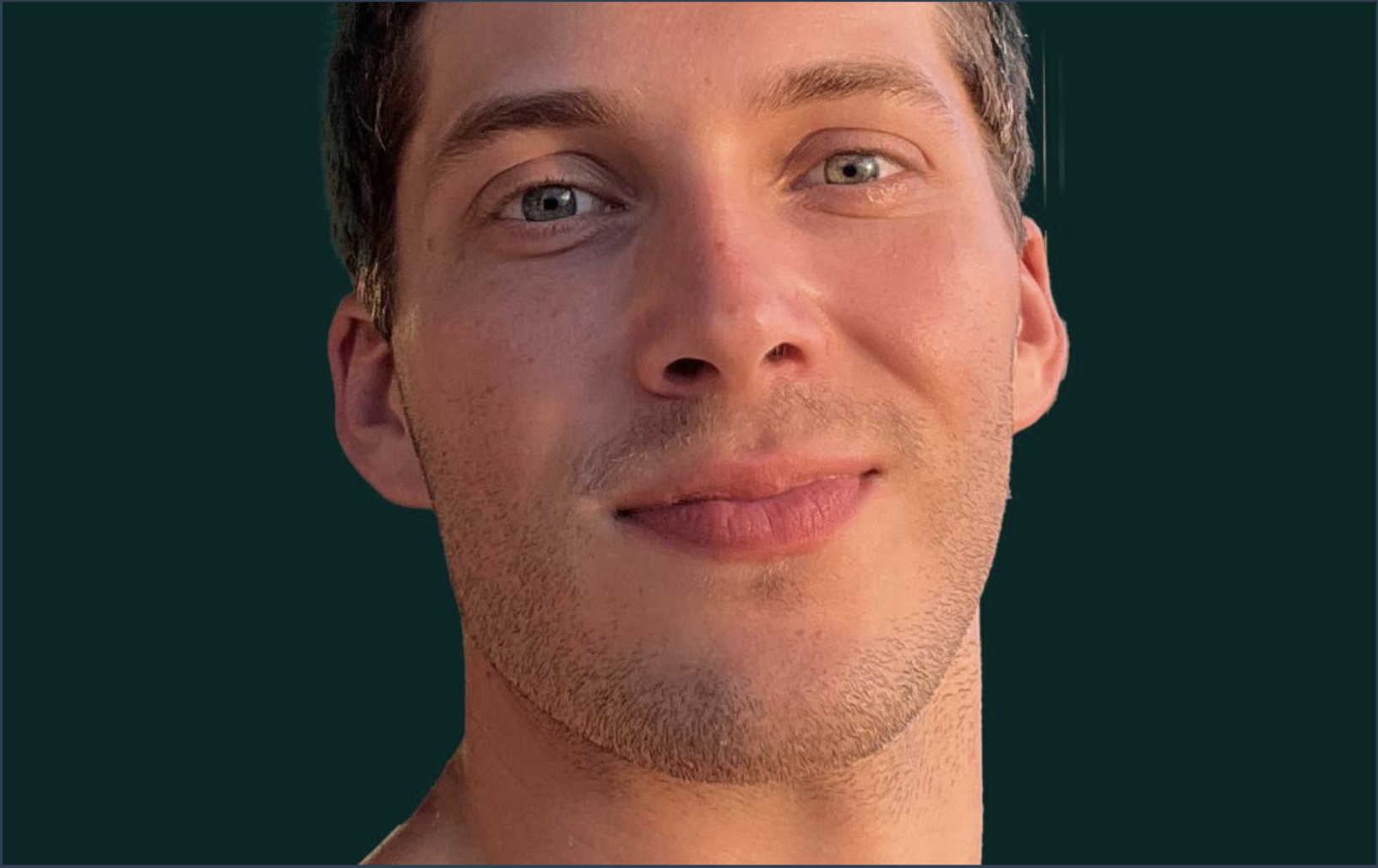 Close-up of a young man with short brown hair, blue eyes, slight facial hair, and a light complexion. He is smiling gently and looking slightly to the right. The background is dark green.
