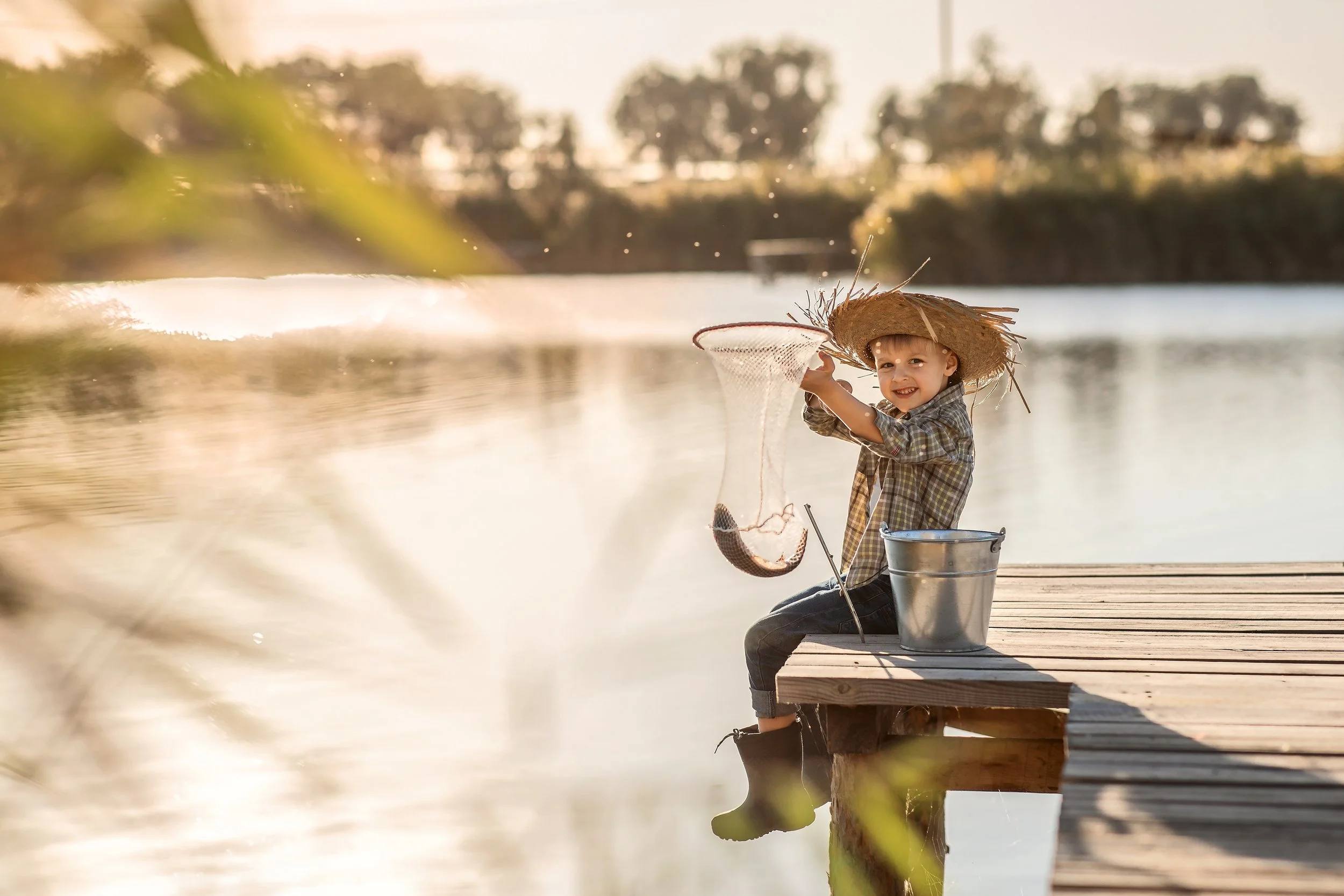 a-boy-in-a-straw-hat-with-a-bucket-and-net-fishing-2023-11-27-05-12-31-utc.jpg