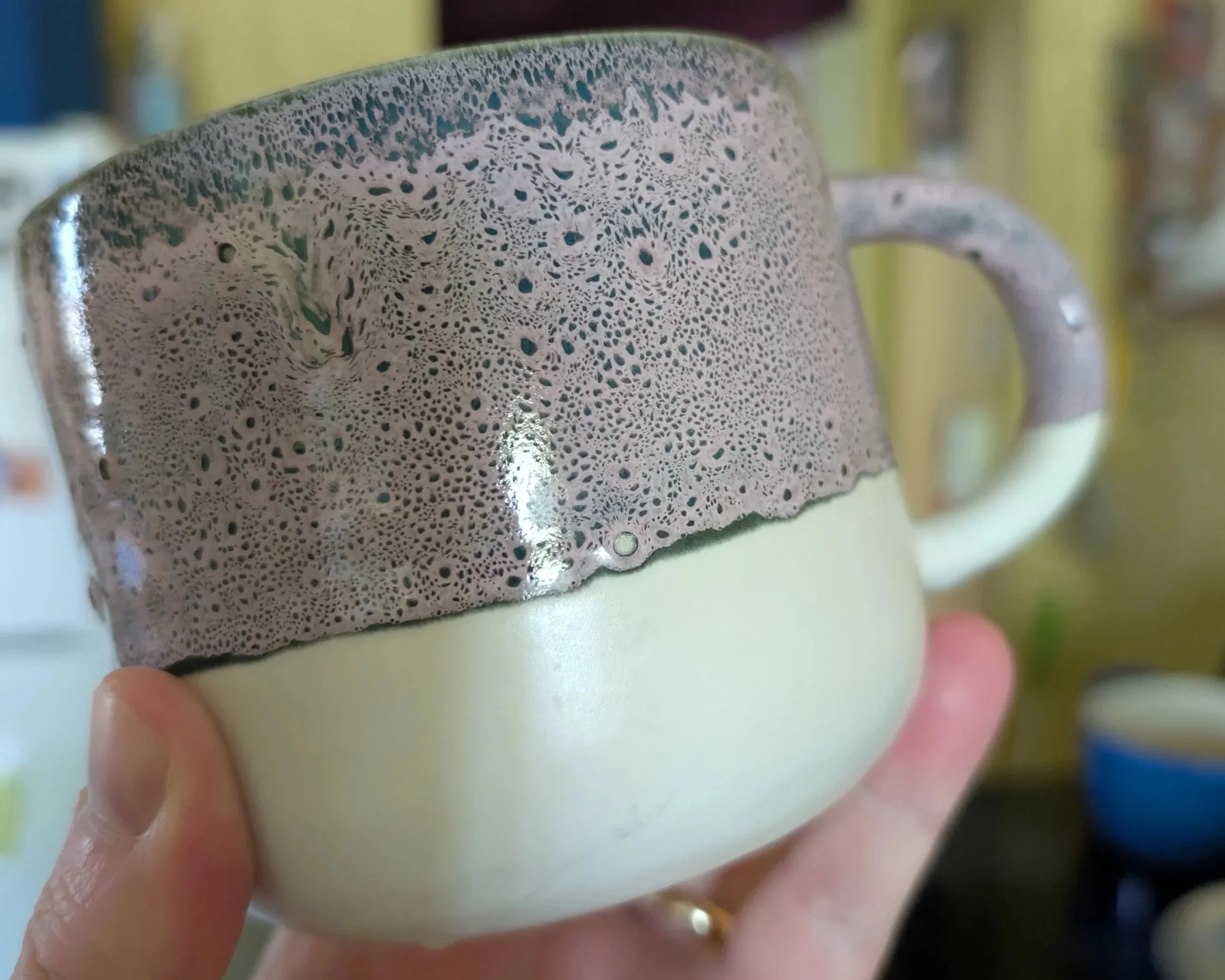 A picture of Dan's favorite mug. It has a purple and black speckled glaze that is featured on the top of the mug. The bottom of the mug is unglazed. This was picked up from a store in Nuremberg, Germany in 2023.