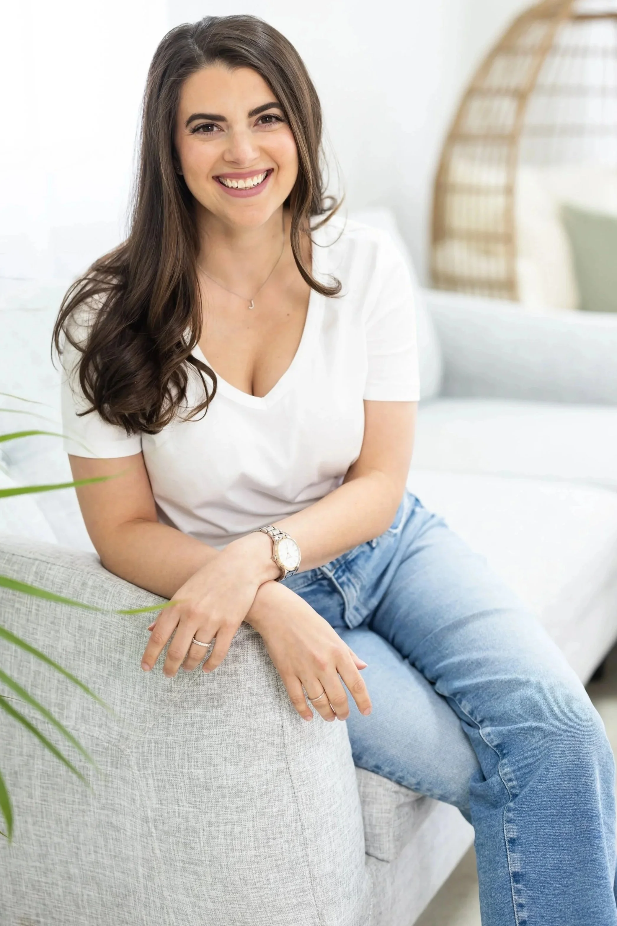 Julie Starr, career transition coach, seated casually on a white couch in a light-filled room, smiling warmly