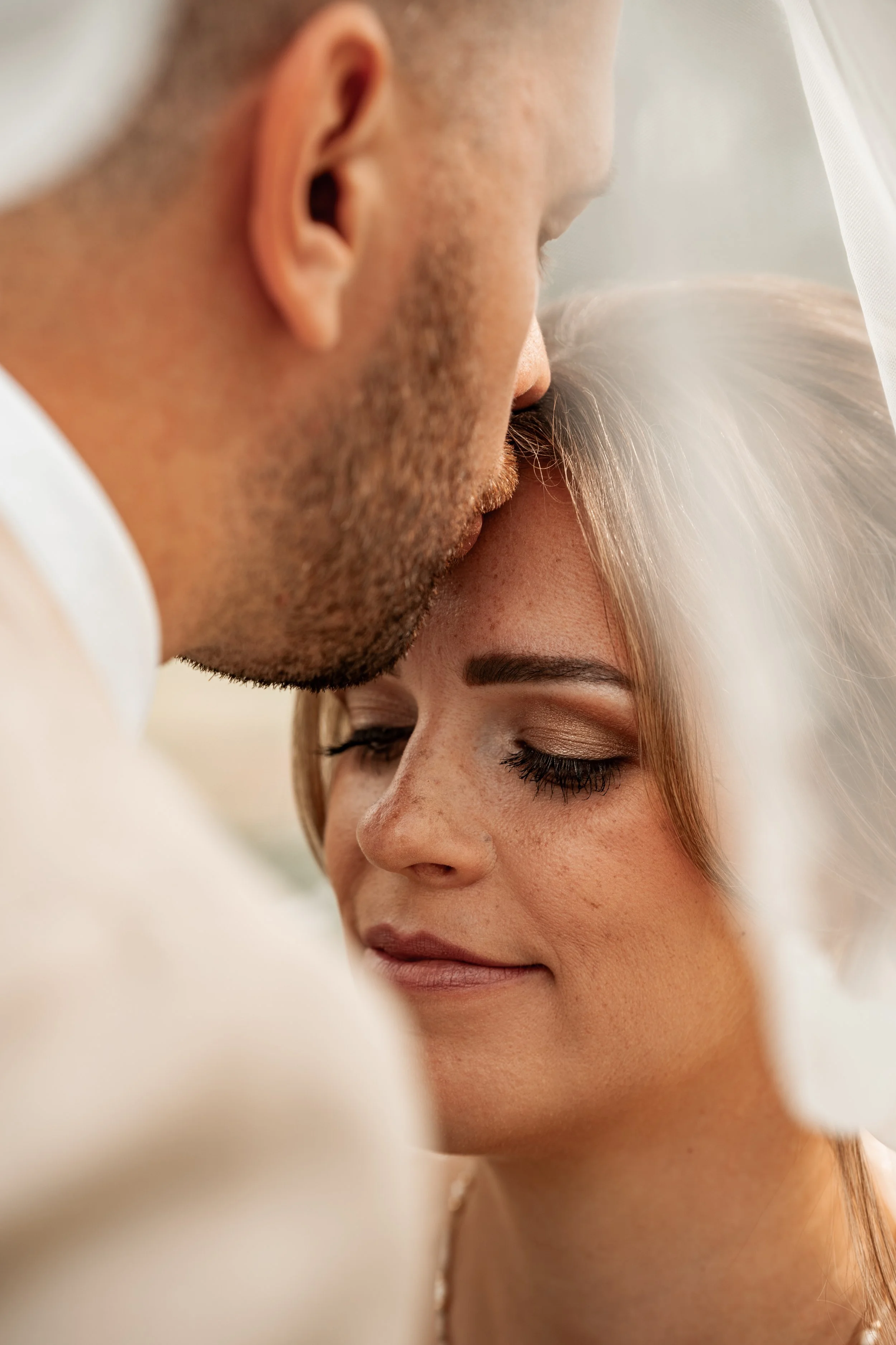Ein Paar, das sich für eine Hochzeit oder einen romantischen Moment nahe kommt, mit geschlossenen Augen und einem friedlichen Ausdruck.