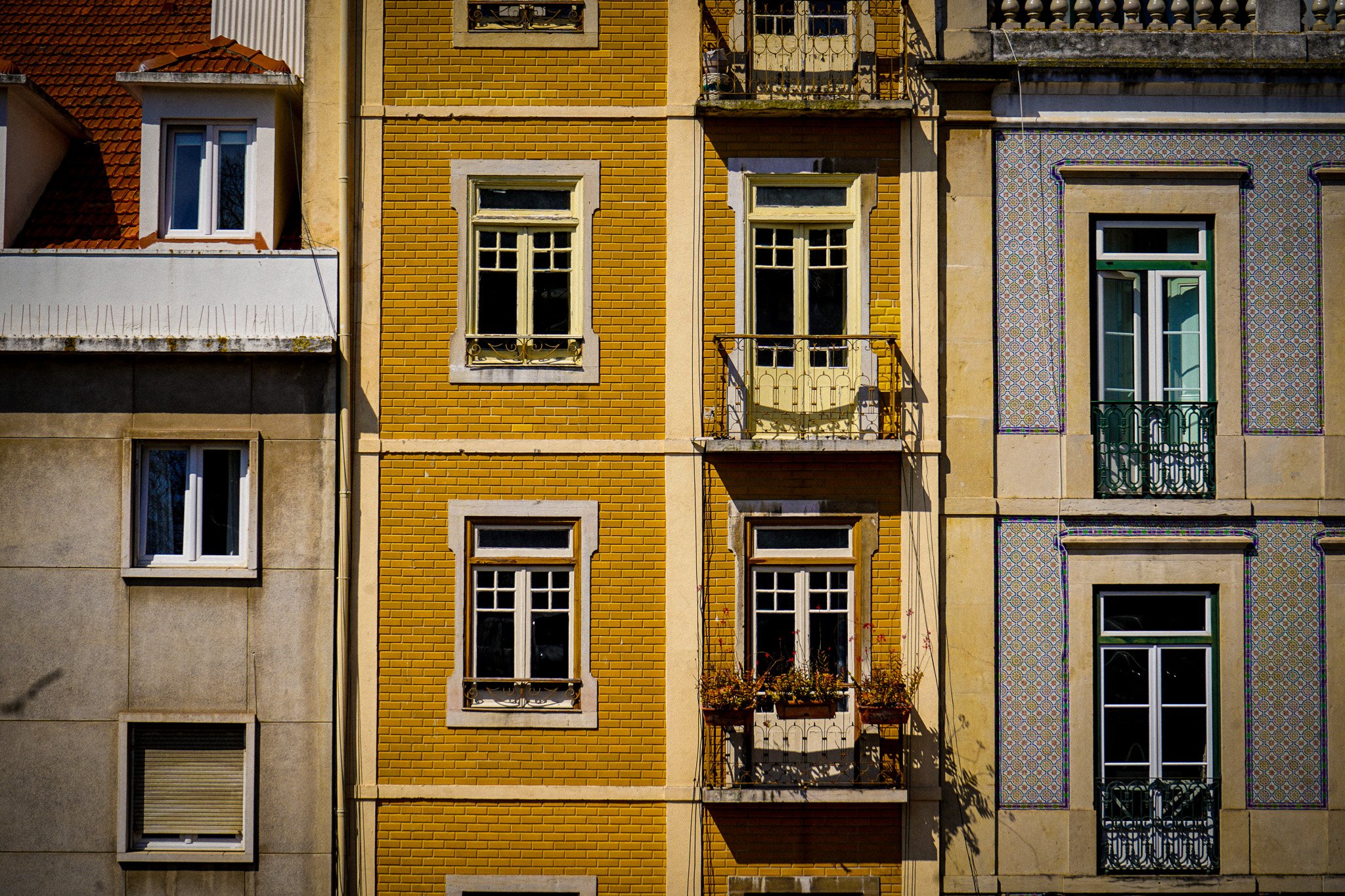 Close-up of colorful buildings with various window styles and decorative tiles on the exterior walls.
