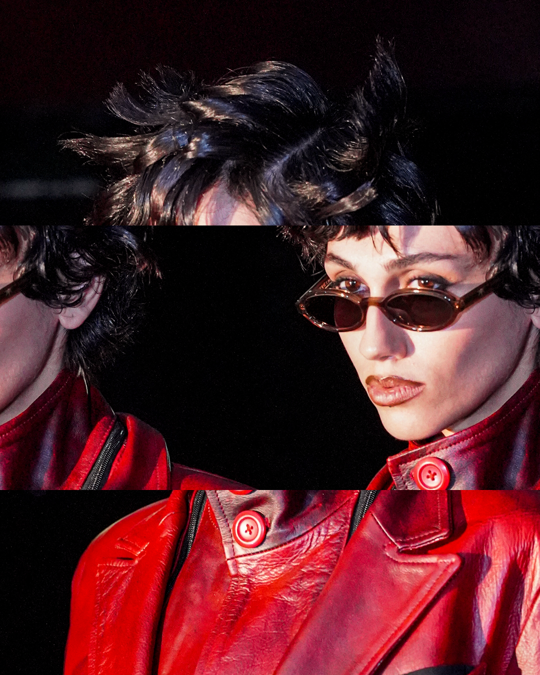 Close-up of a woman with short curly black hair, wearing oval sunglasses and a red leather jacket with buttons, against a dark background.