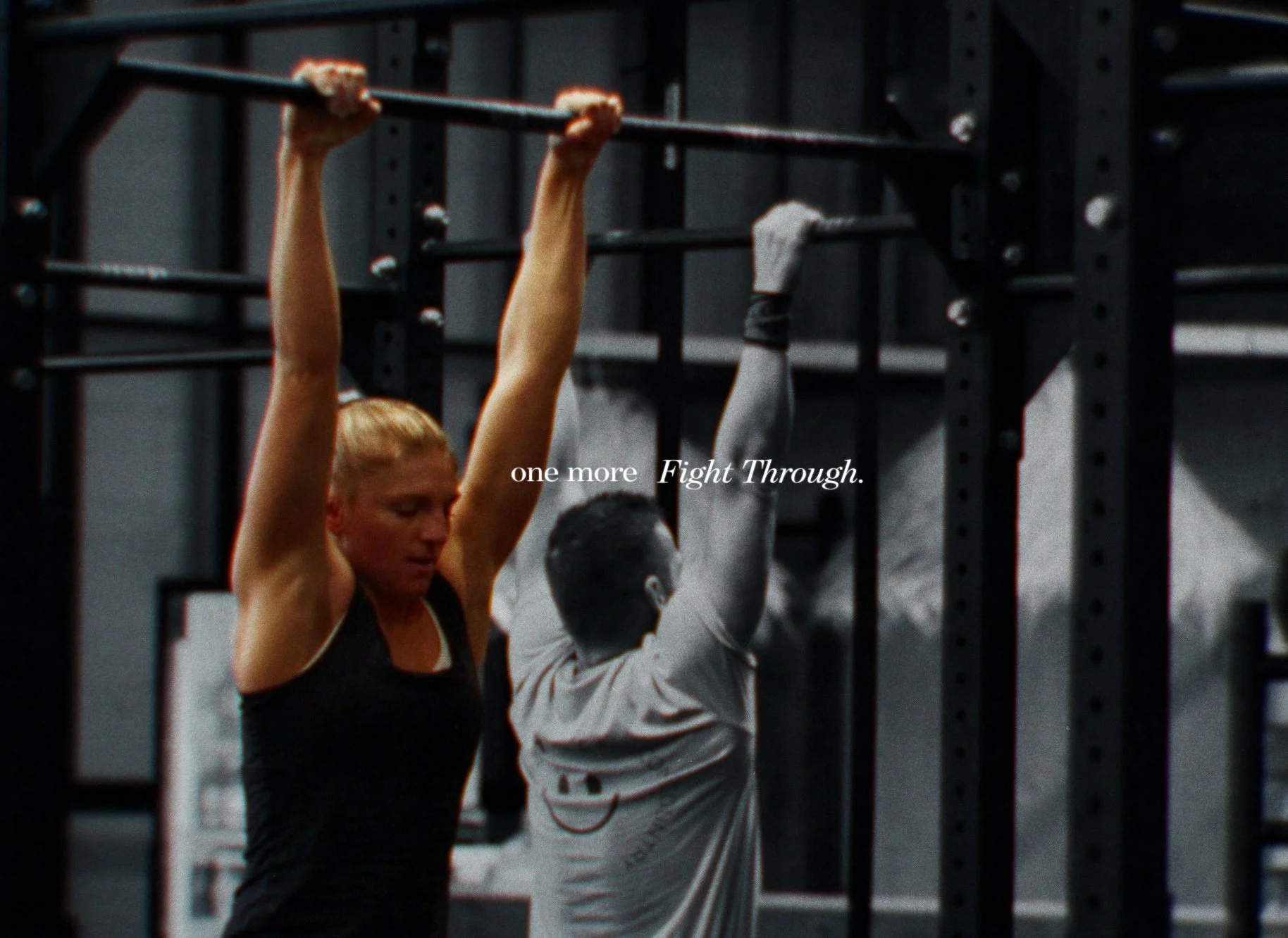 Eine Frau beim Krafttraining an einer Stange im Fitnessstudio, im Hintergrund sind weitere Personen und Fitnessgeräte. Der Text auf dem Bild lautet: "one more Fight Through."