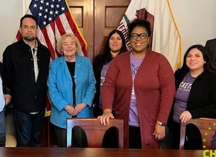 A photo of a group of leaders smiling in front of the USA flag.