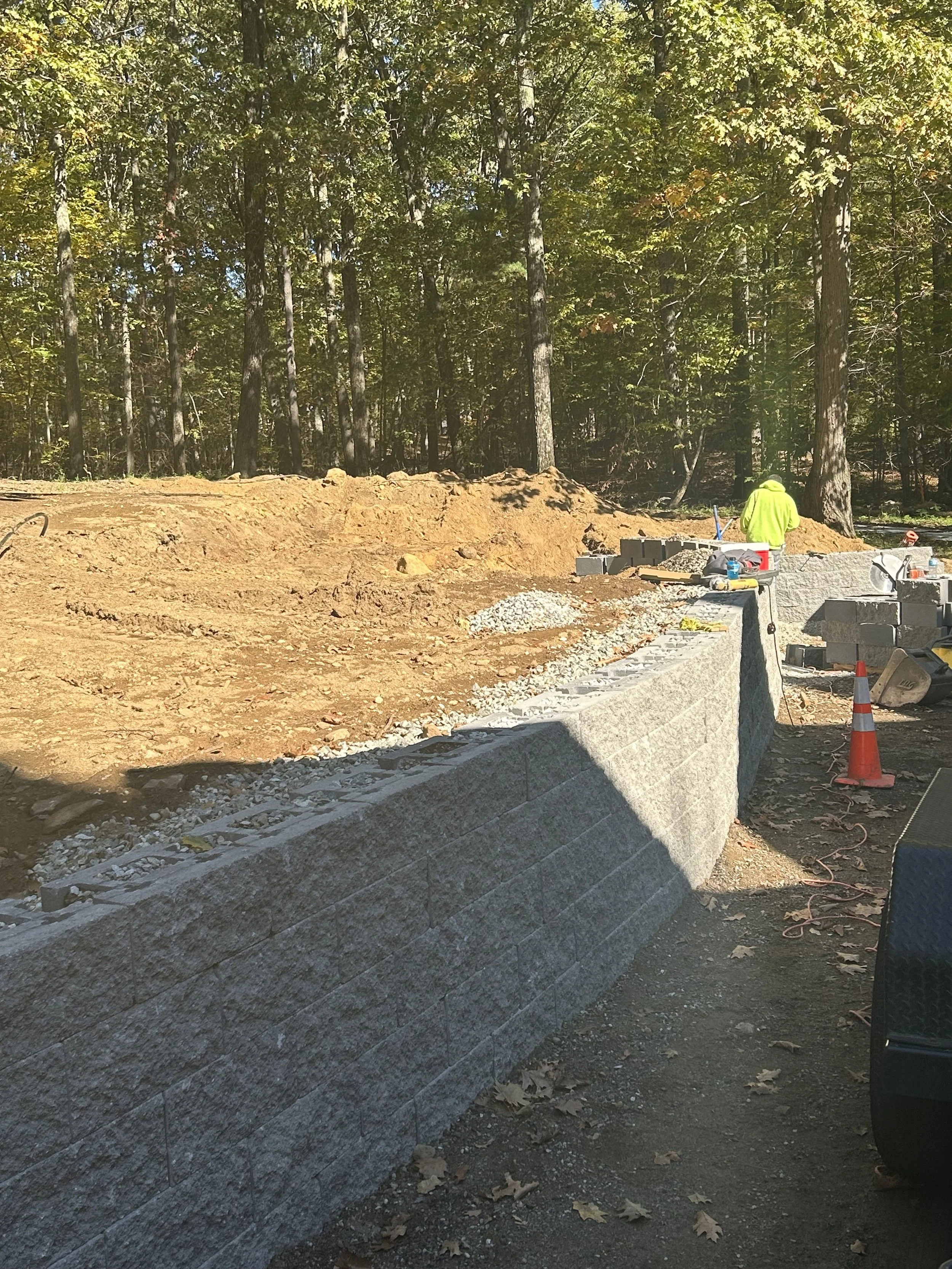 Retaining wall installation with stone and pipe
