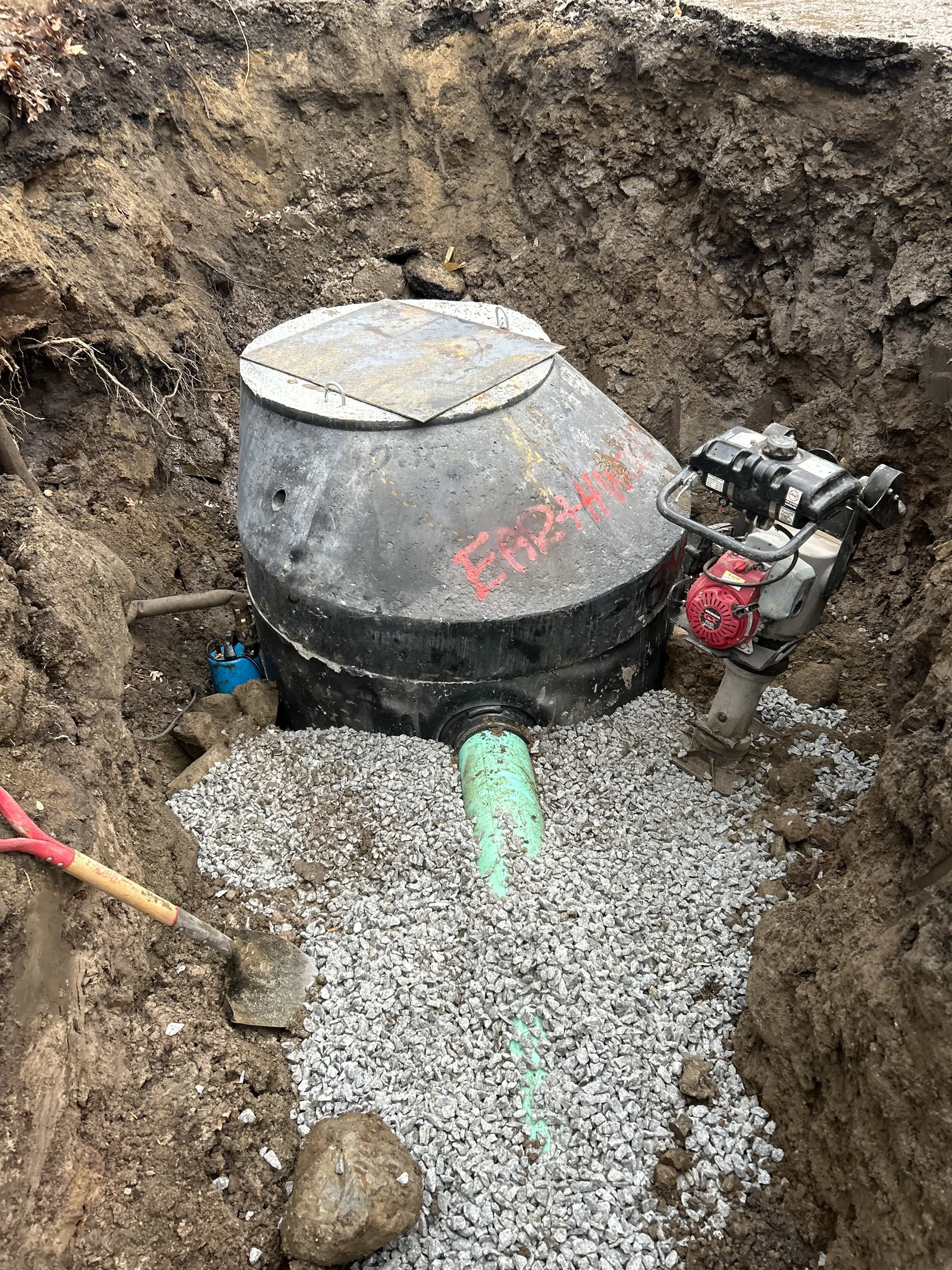 Utility crew installing precast sewer manhole and connecting the pipe