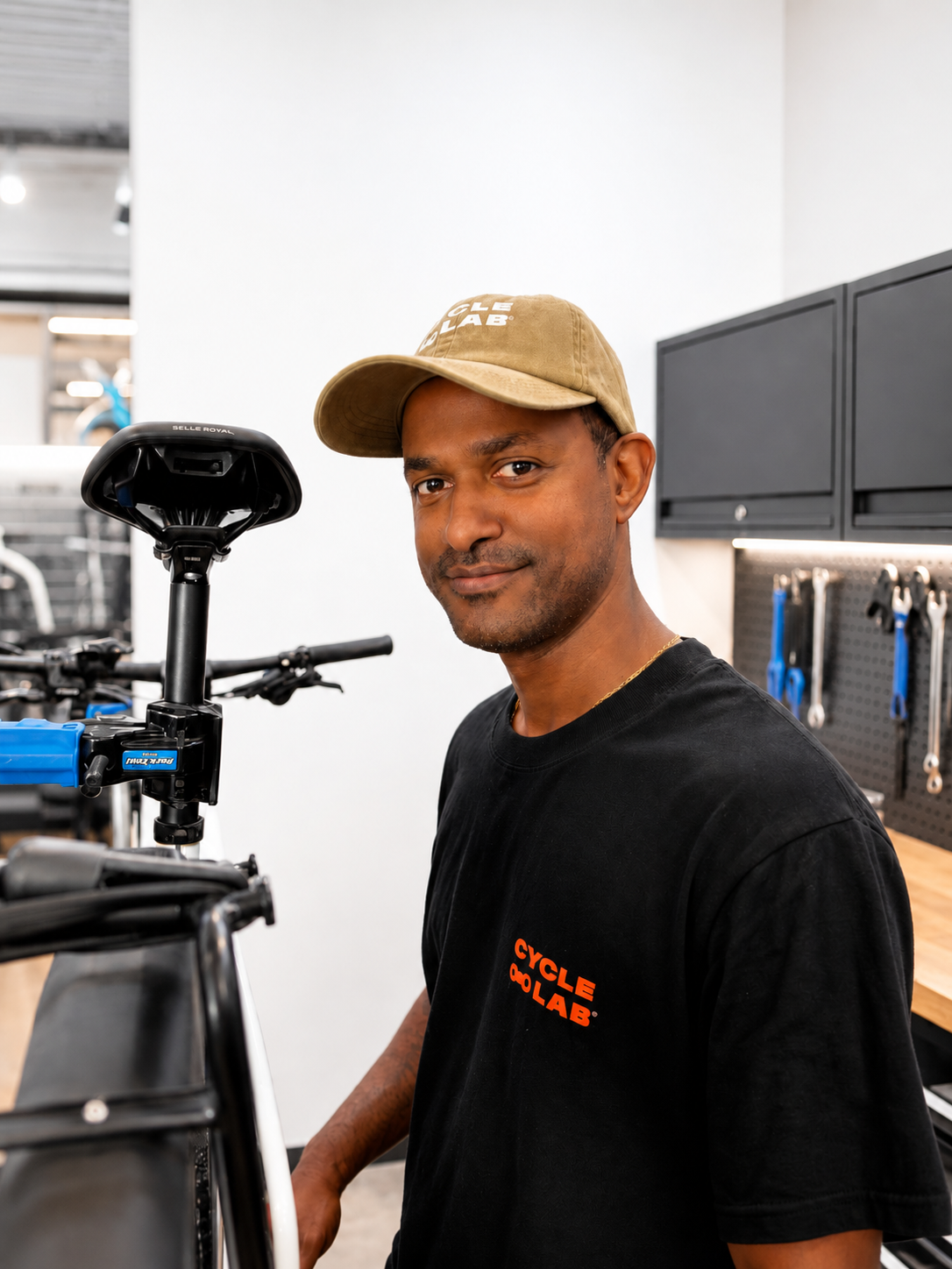A man smiling and holding a colorful mountain bike frame indoors.