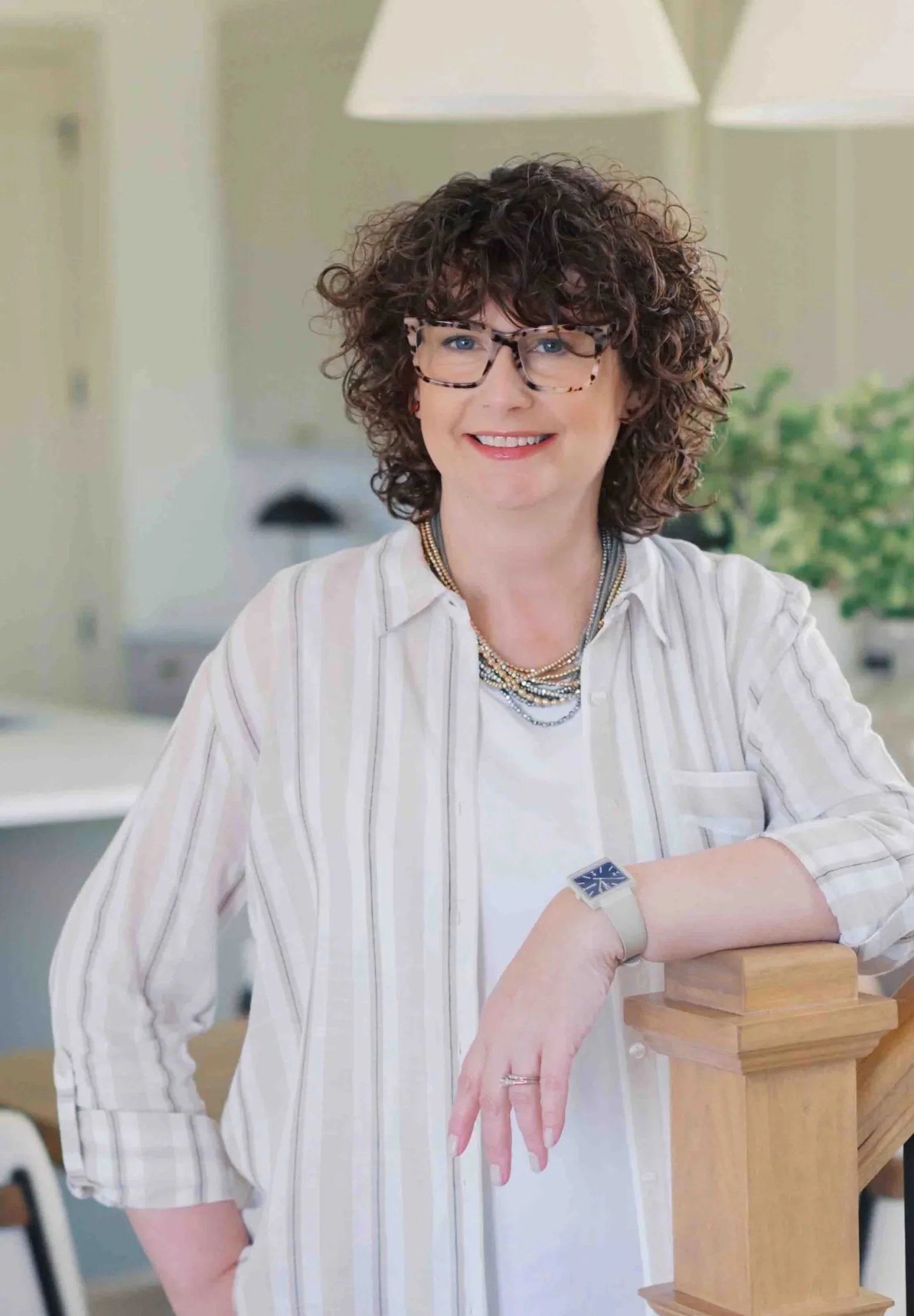 Nichole Alspaugh Williams smiling and standing by staircase