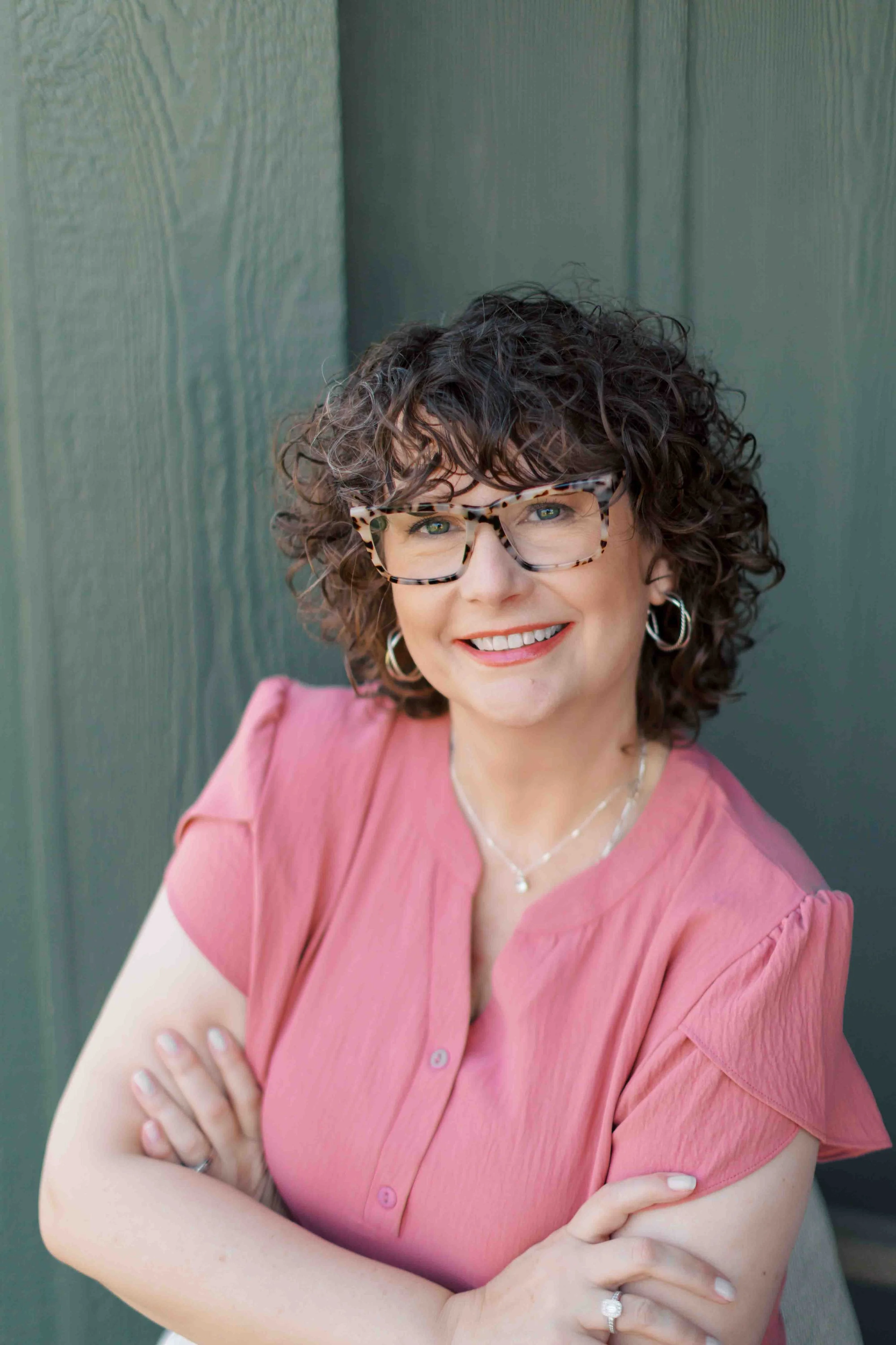 Nichole alspaugh williams therapist in bloomington smiling and standing in front of a wall